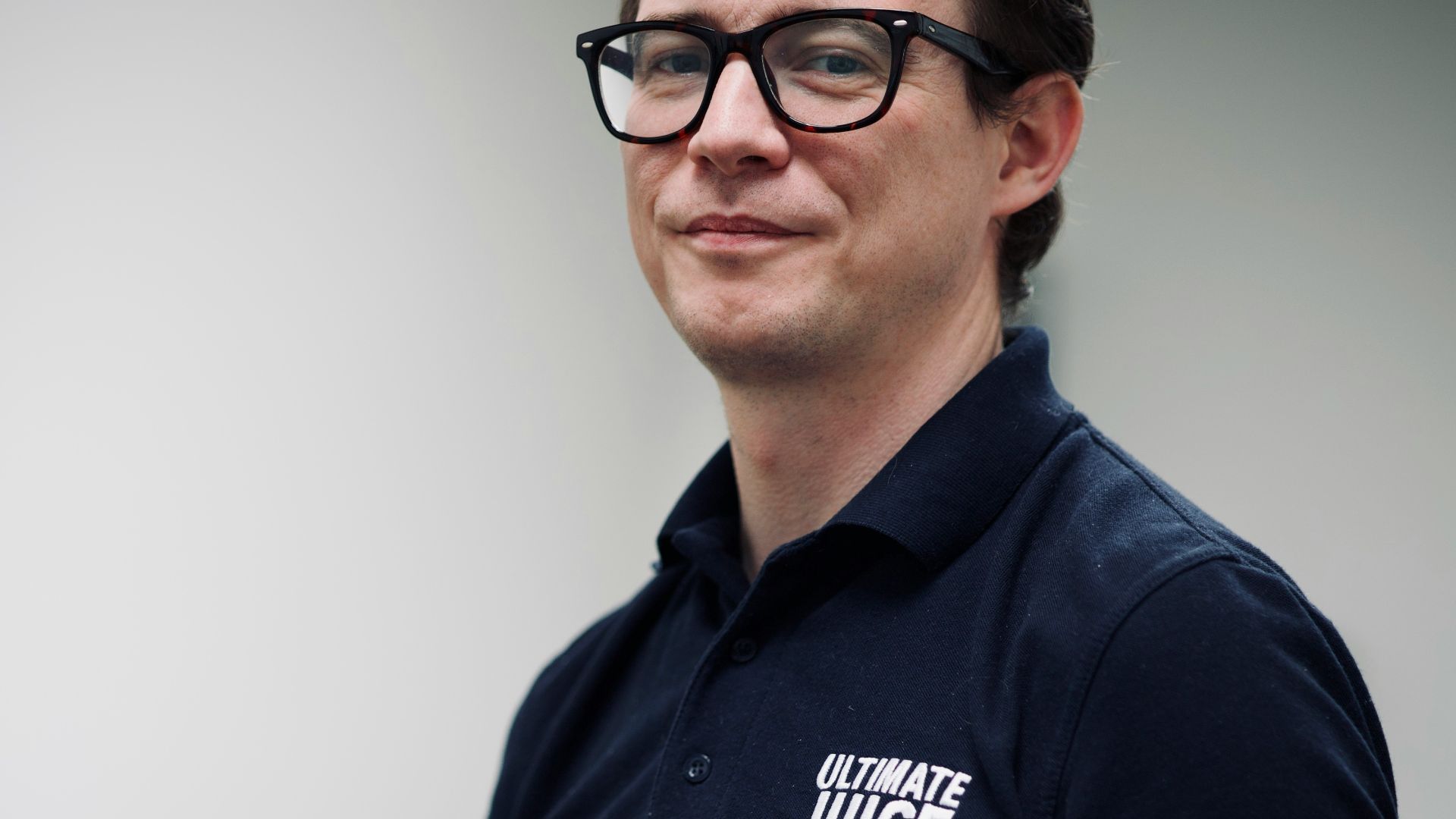 A man with glasses holding a cup of coffee