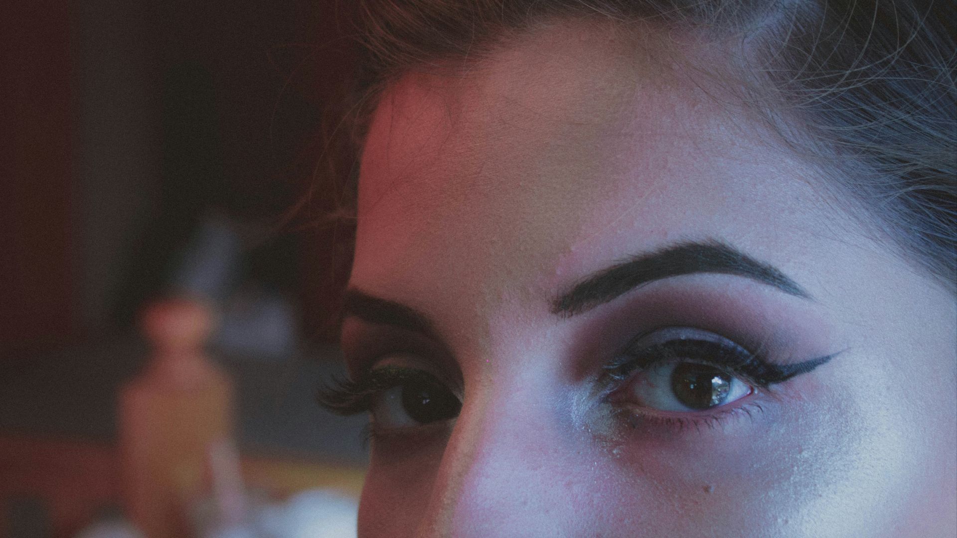 woman with brown hair and black eye shadow