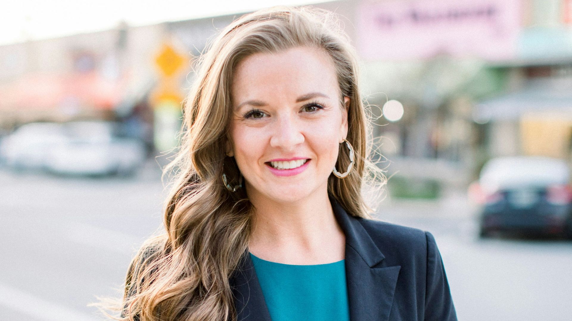 woman in black blazer smiling