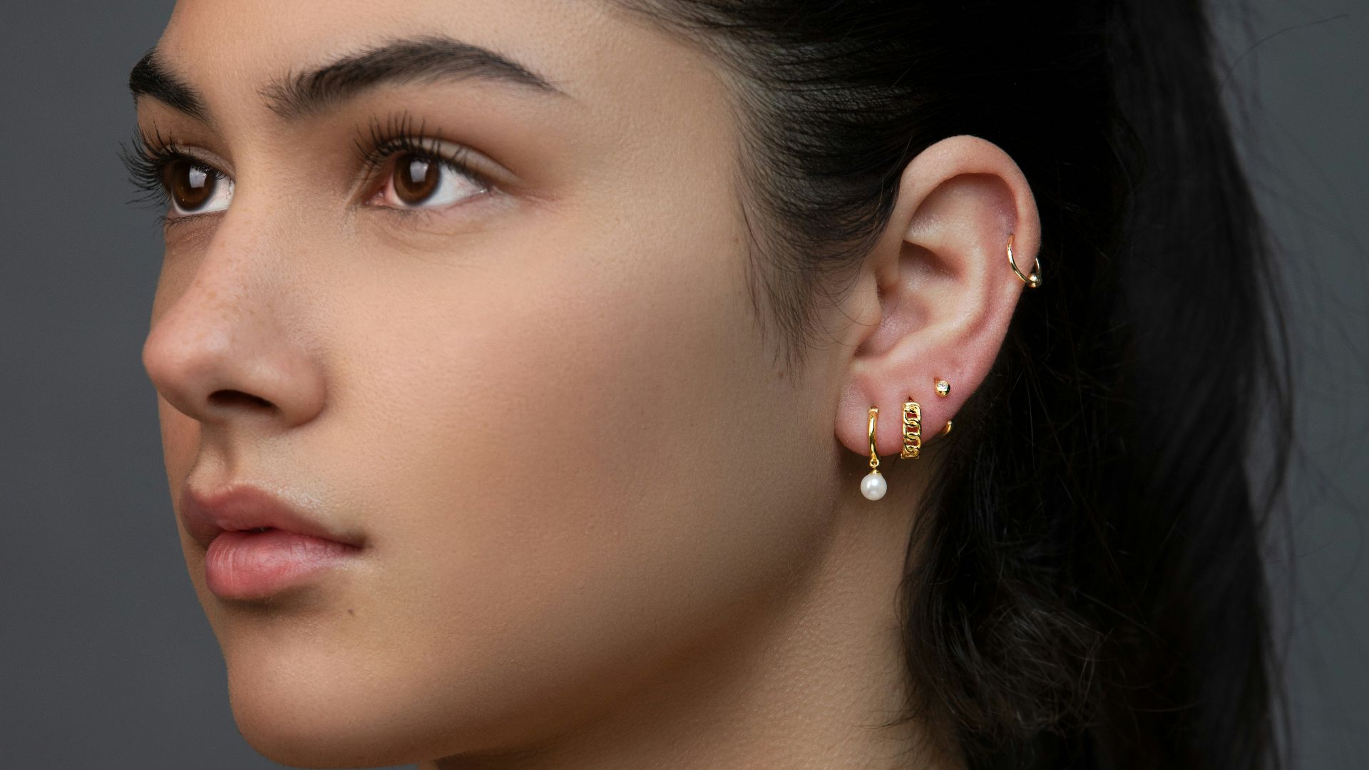 woman with silver and diamond stud earrings