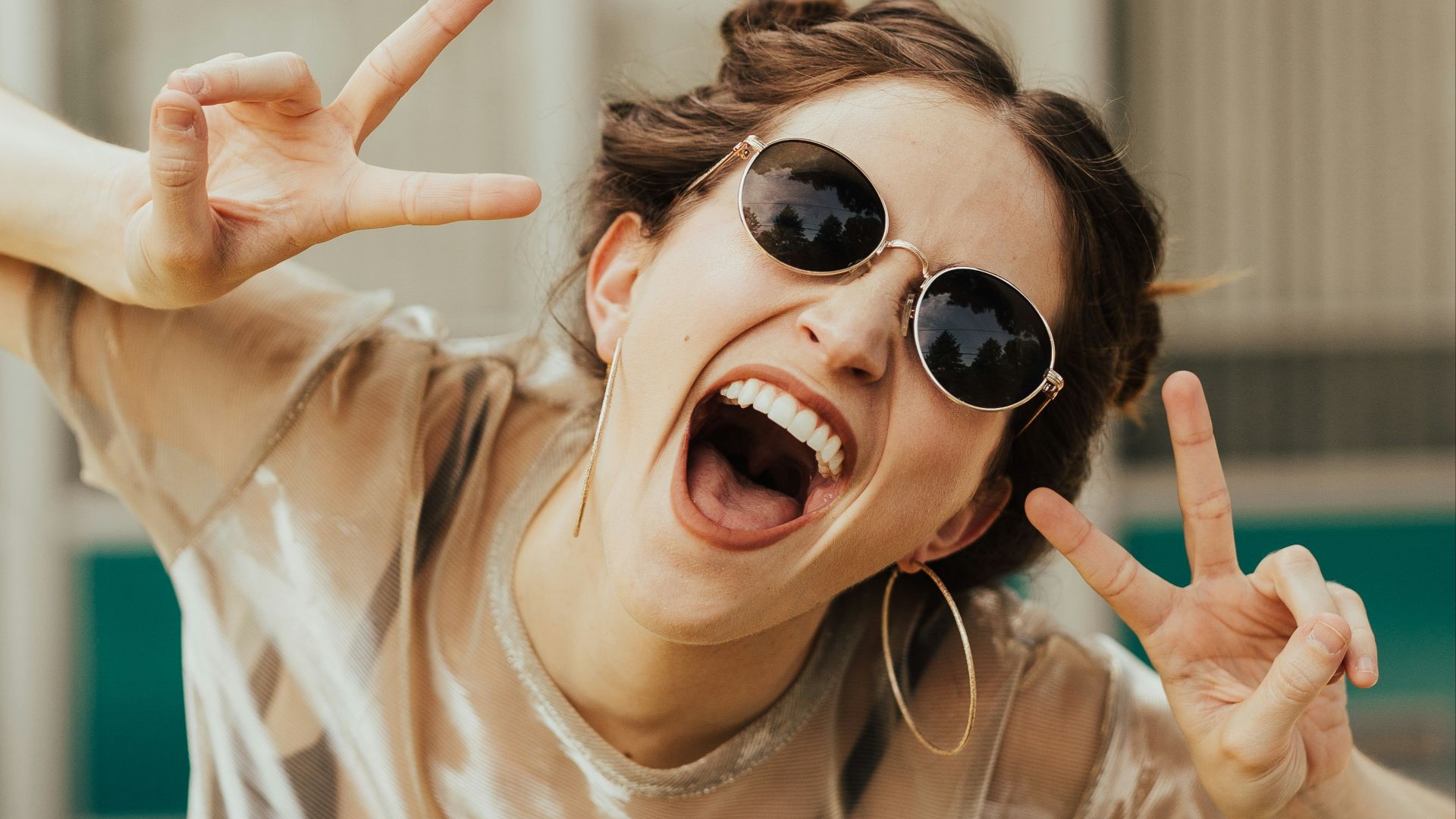 selective focus photography of jolly woman using peace hand gesture