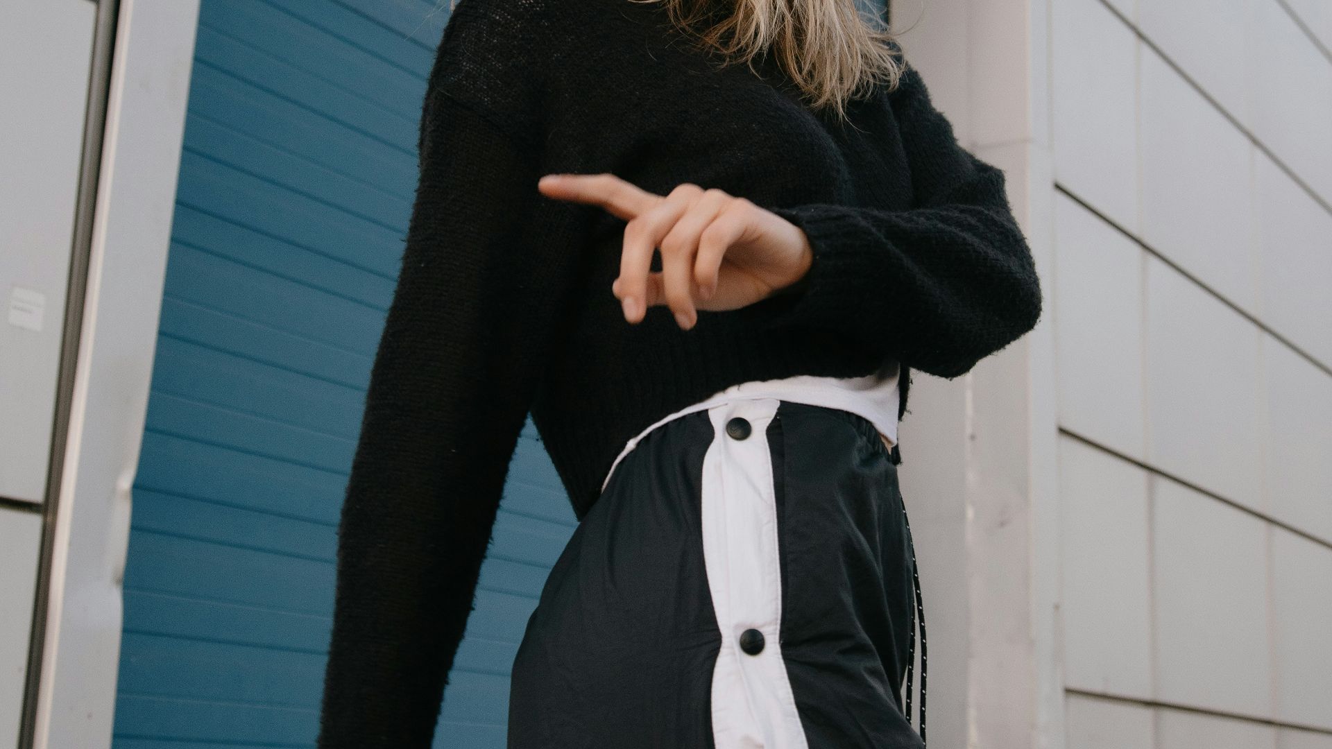 woman in black cardigan standing beside white wooden door