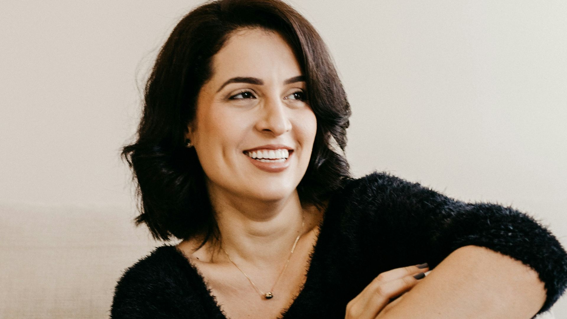 woman in black long sleeve shirt sitting on white couch