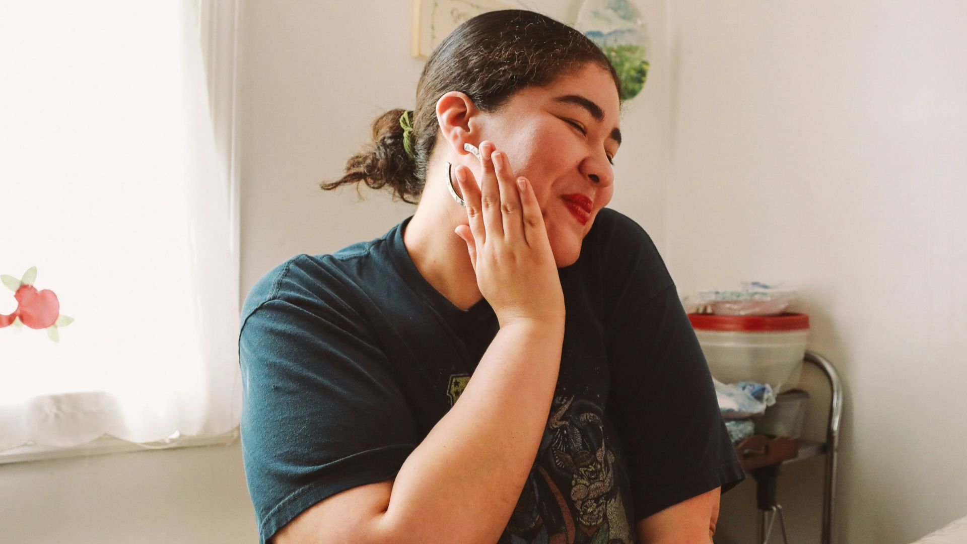 A woman standing in a kitchen talking on a cell phone