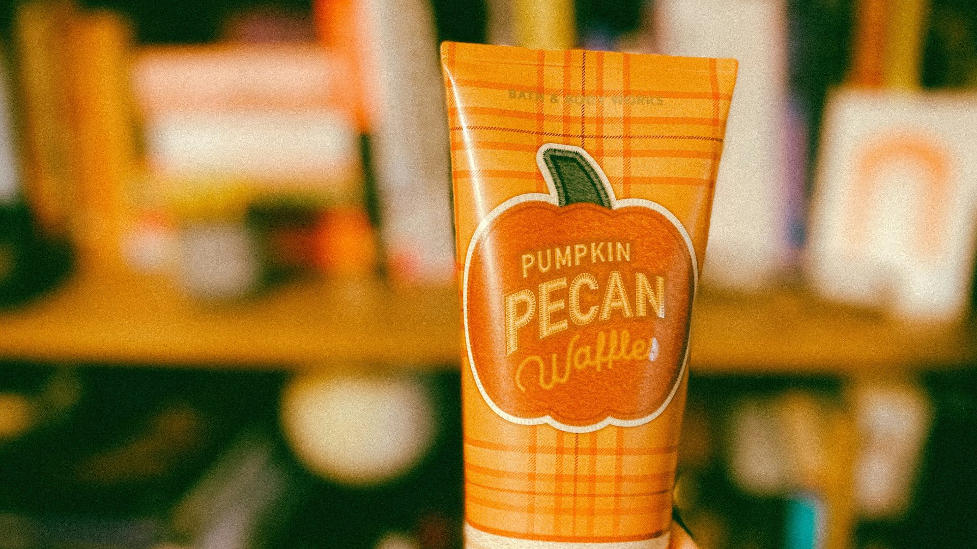 a hand holding a bottle of orange liquid