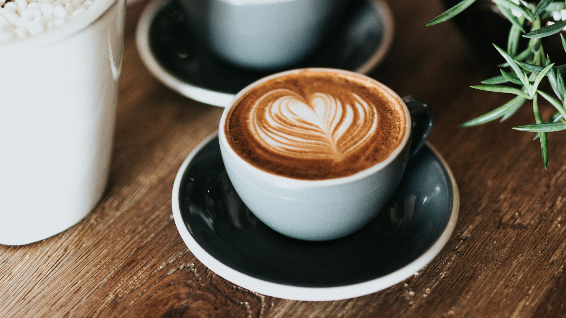 shallow focus photography of coffee late in mug on table