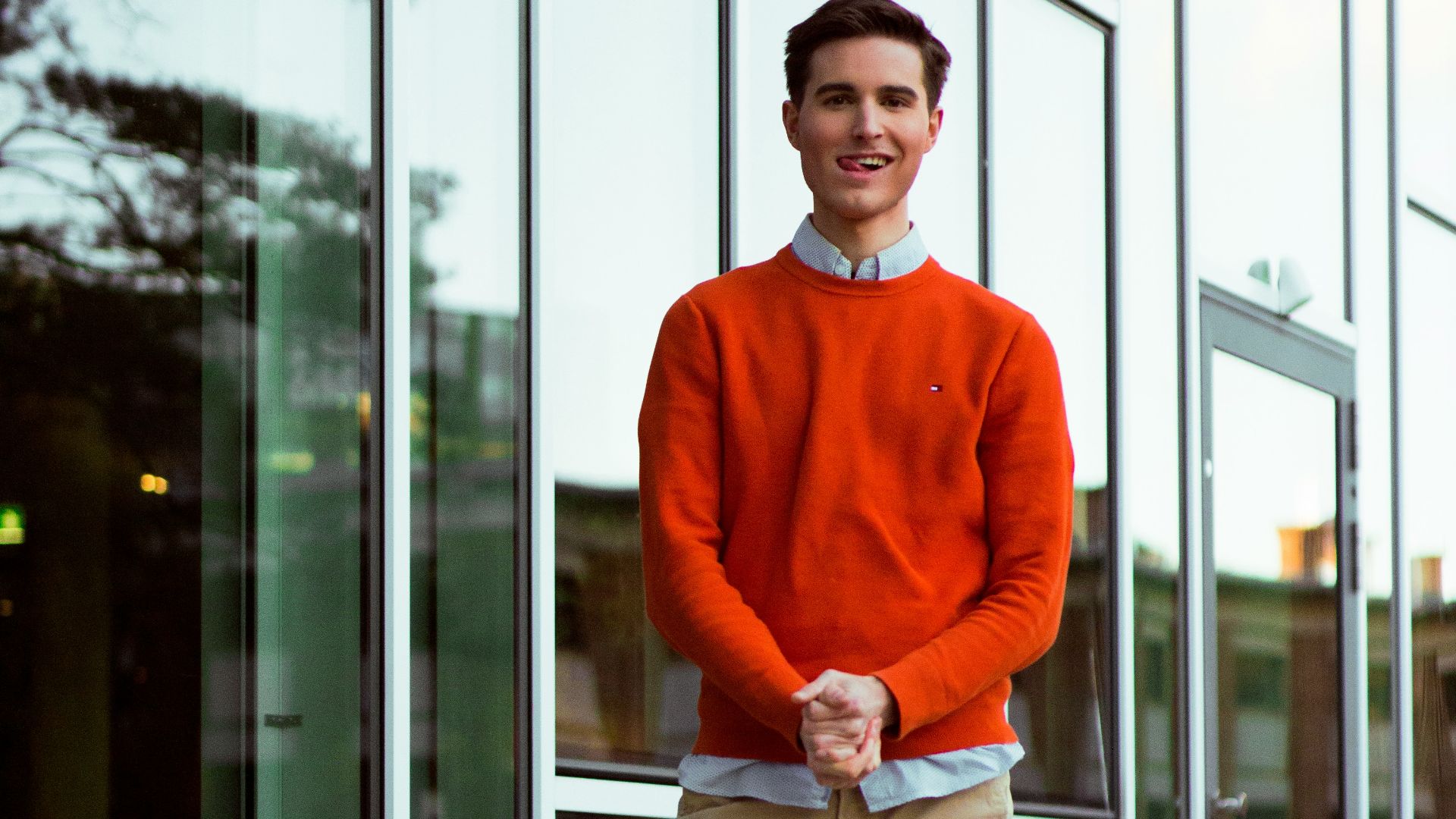 a man standing on a sidewalk in front of a building