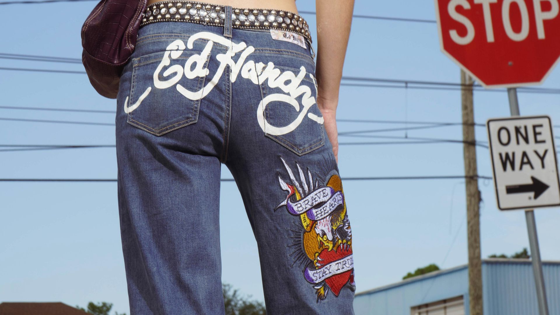 Woman wearing ed hardy jeans at a street corner