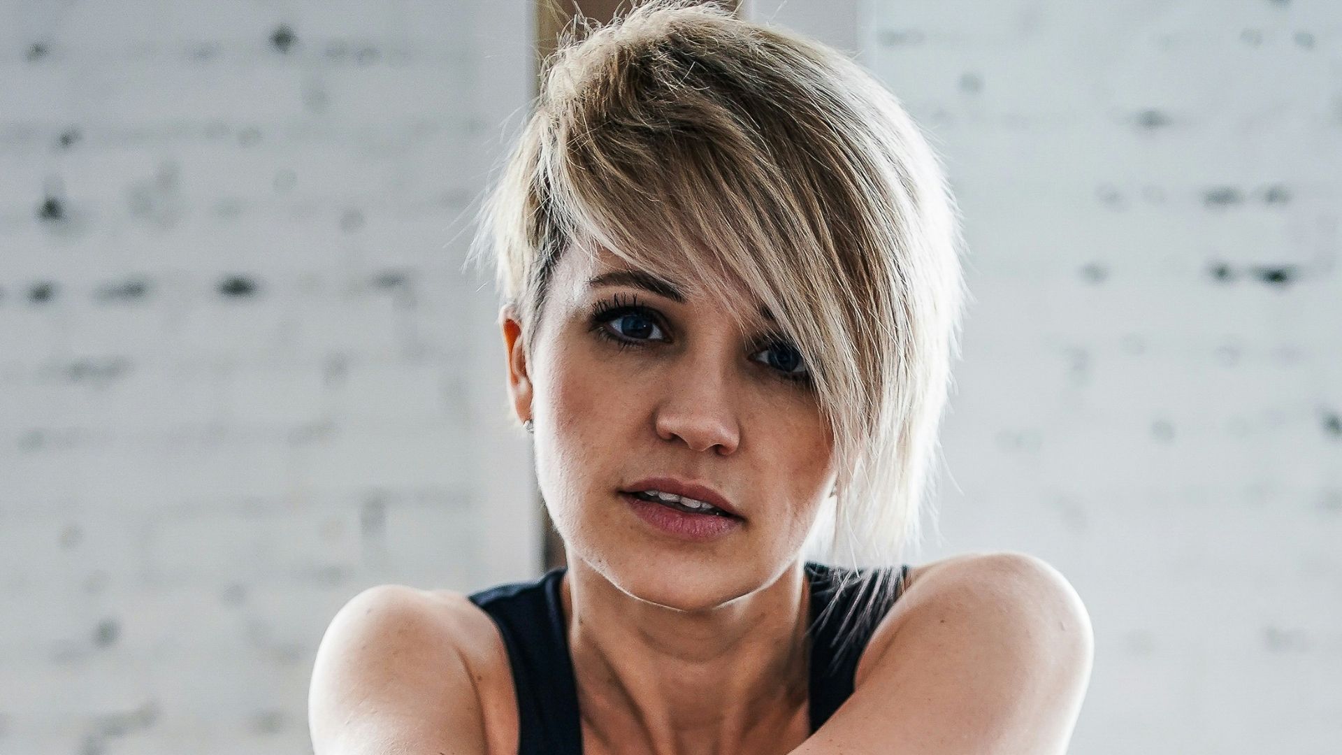 woman in black tank top and black skirt sitting on black chair