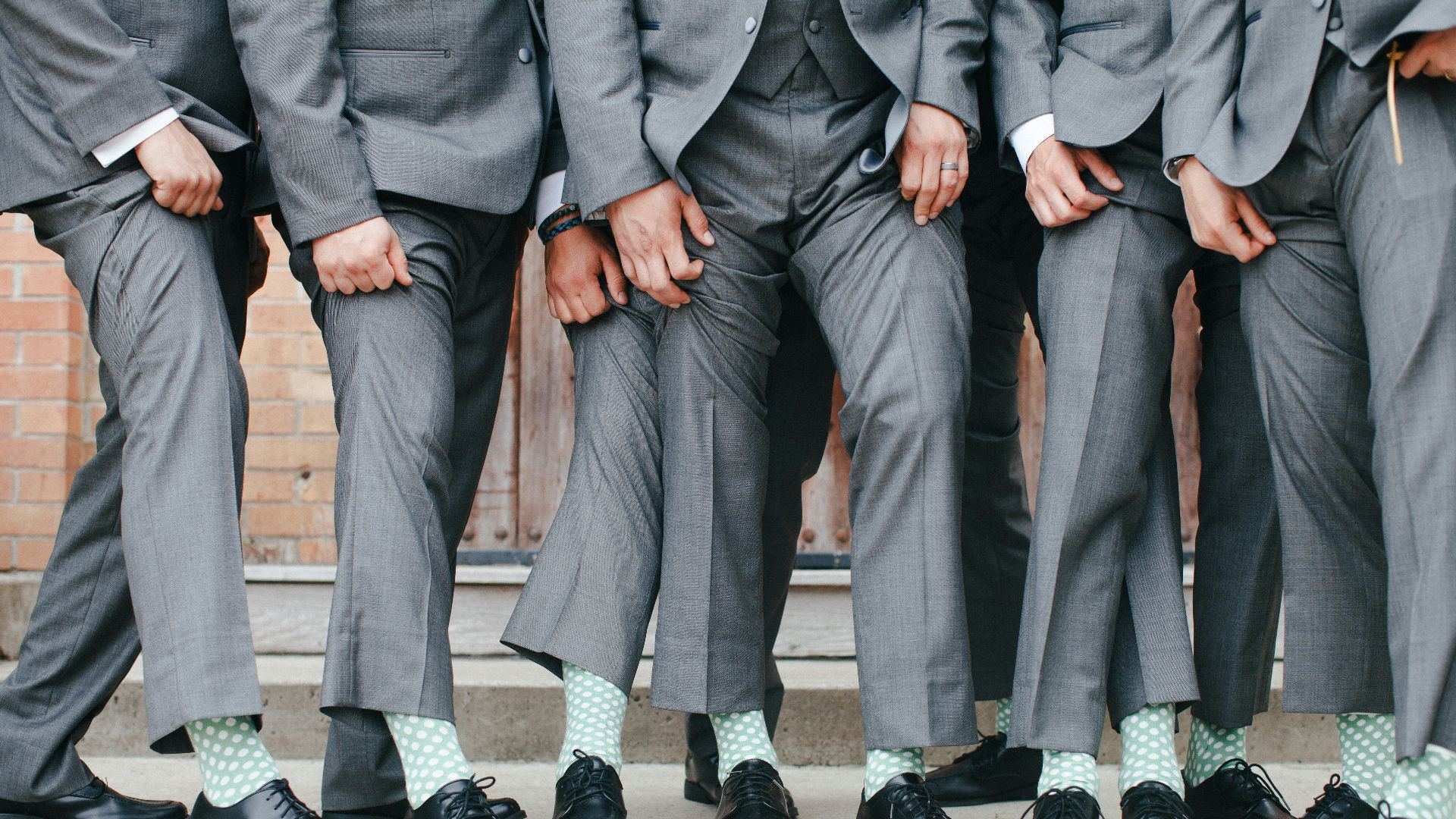 Group of men in grey suits and patterned socks