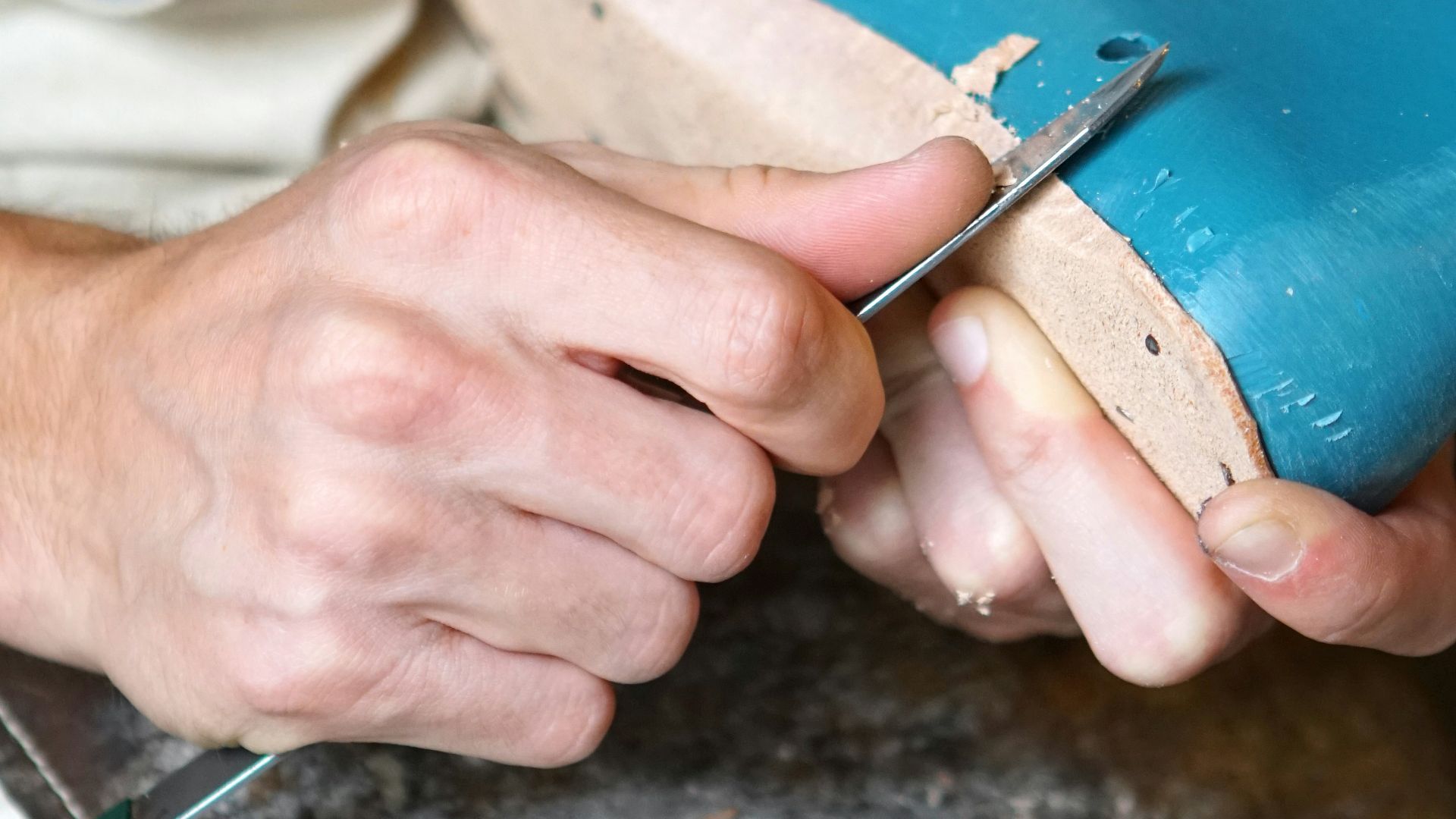 person carving blue footwear
