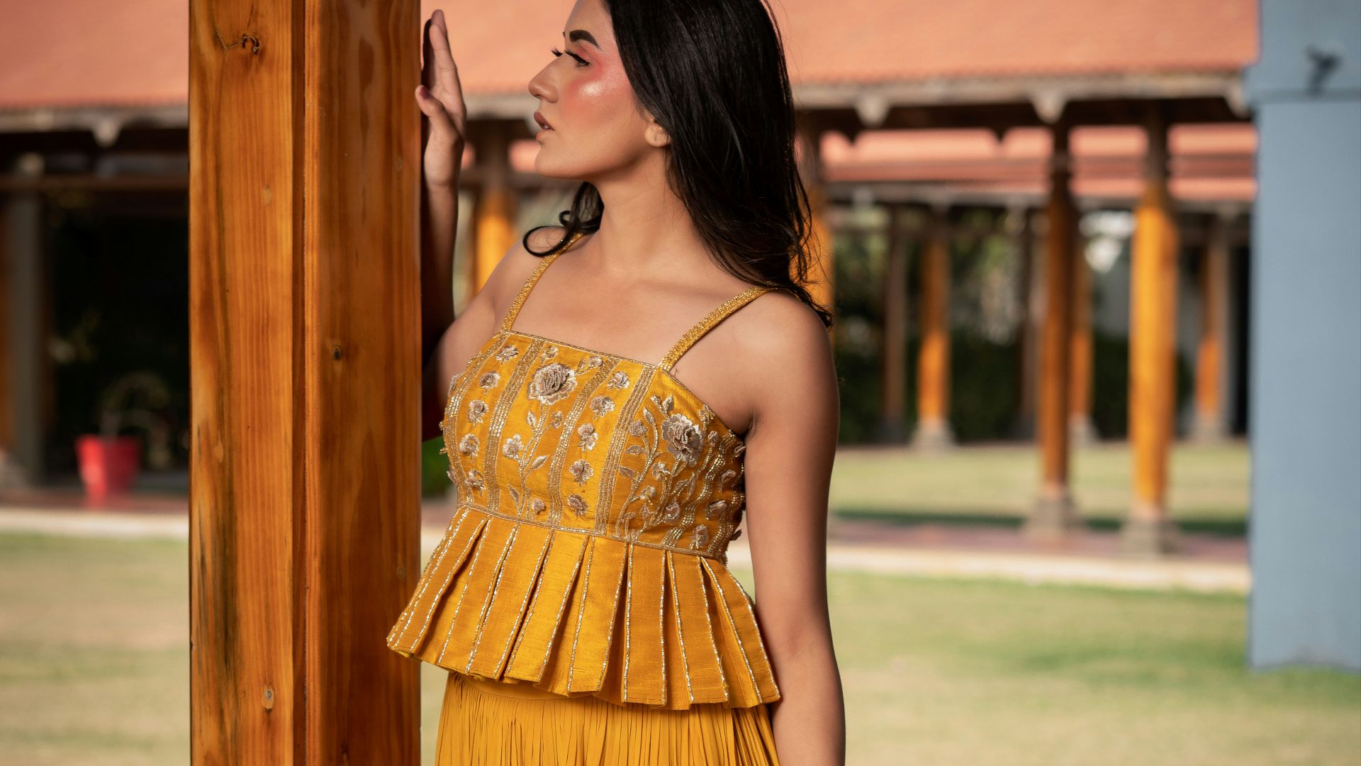 Woman in yellow peplum top and pleated skirt
