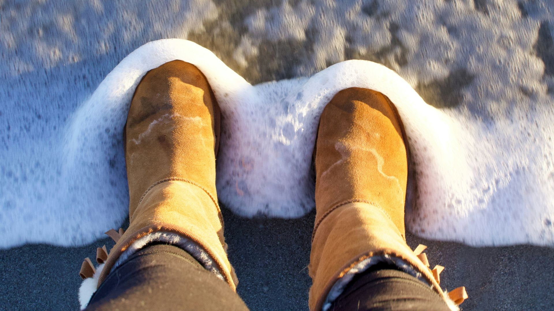 person in brown winter boots standing on snow covered ground