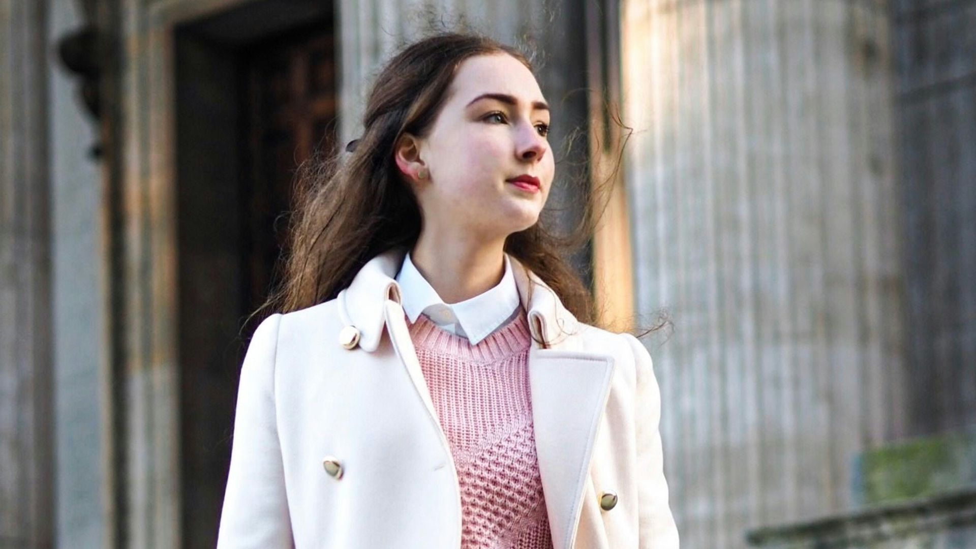 woman wearing white coat carrying crossbody bag