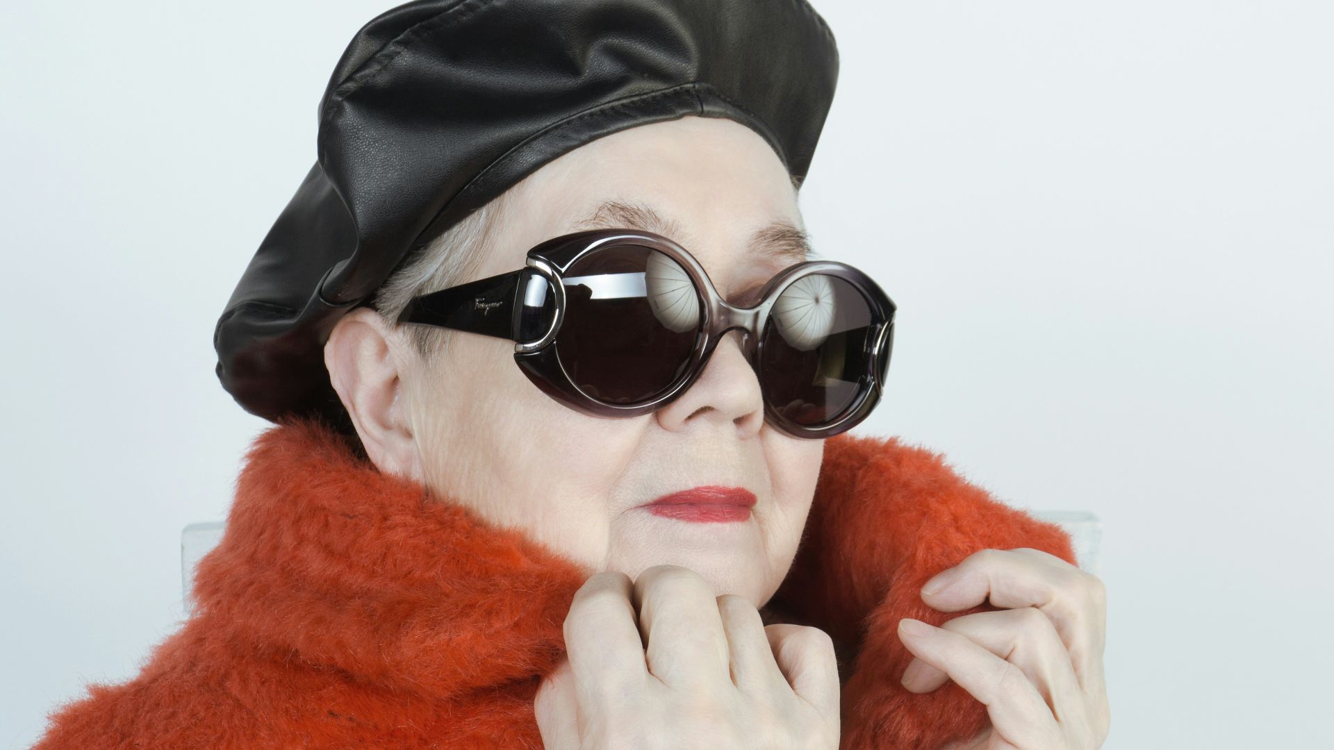 woman in black knit cap and white framed sunglasses