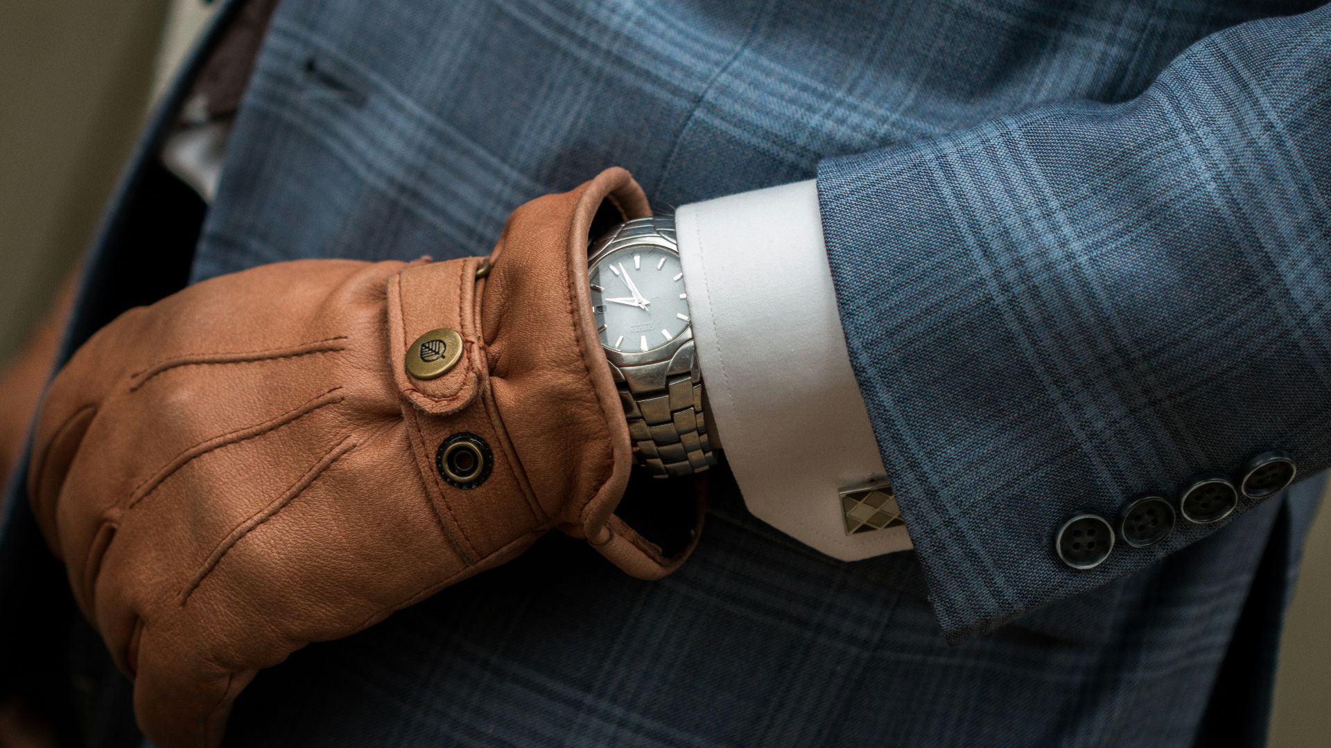 person wearing blue leather gloves with watch