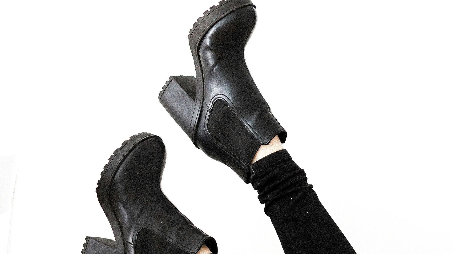 person wearing black leather boots