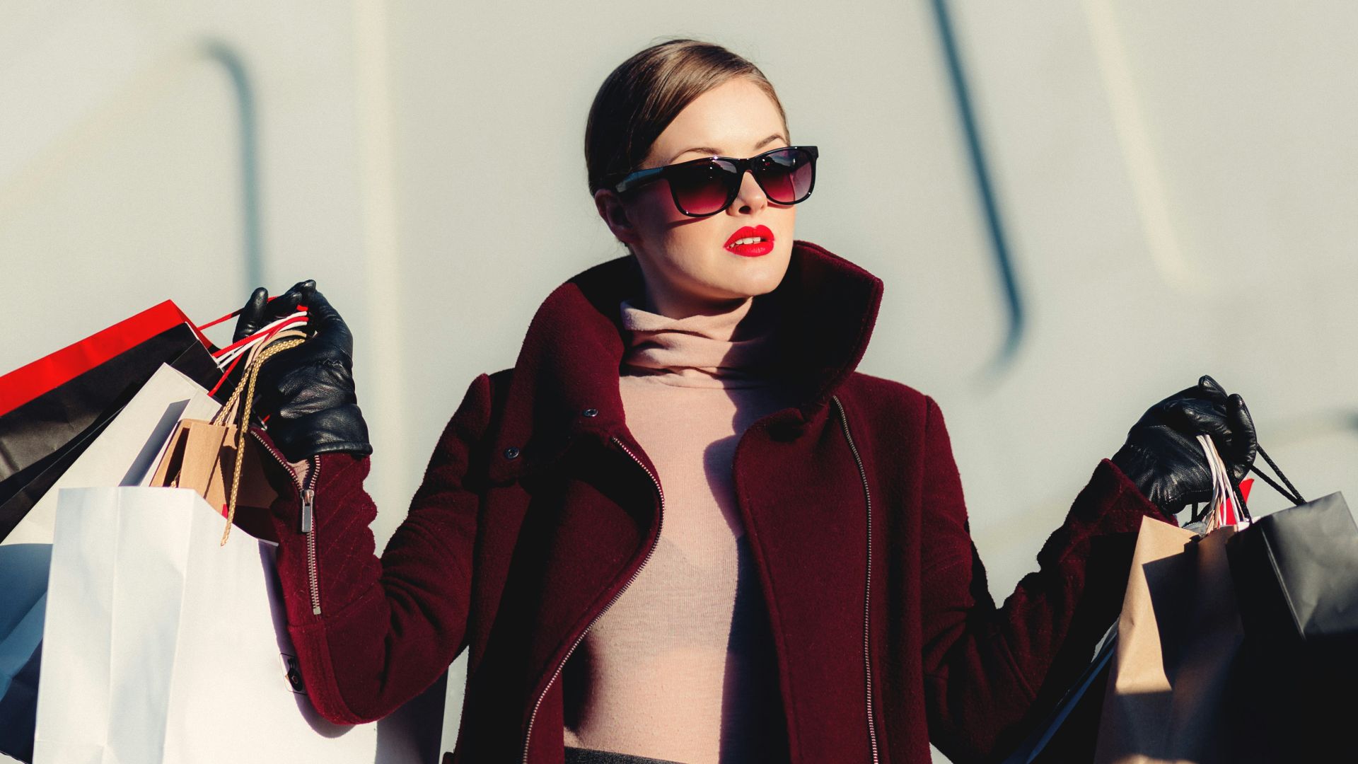 photo of woman holding white and black paper bags