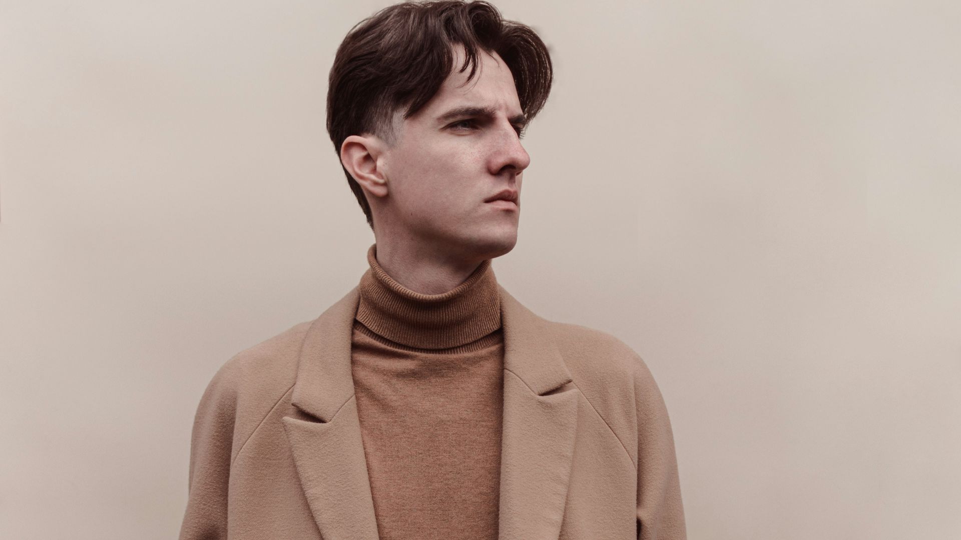 man in brown coat and black pants