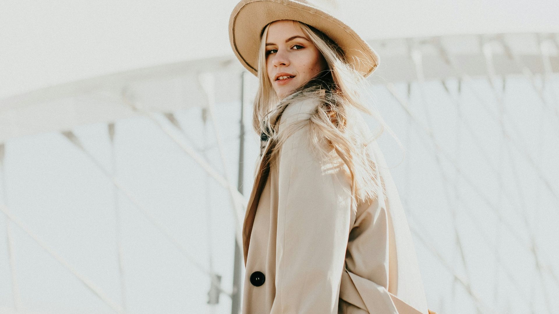 woman in brown coat wearing brown hat standing on snow covered ground during daytime