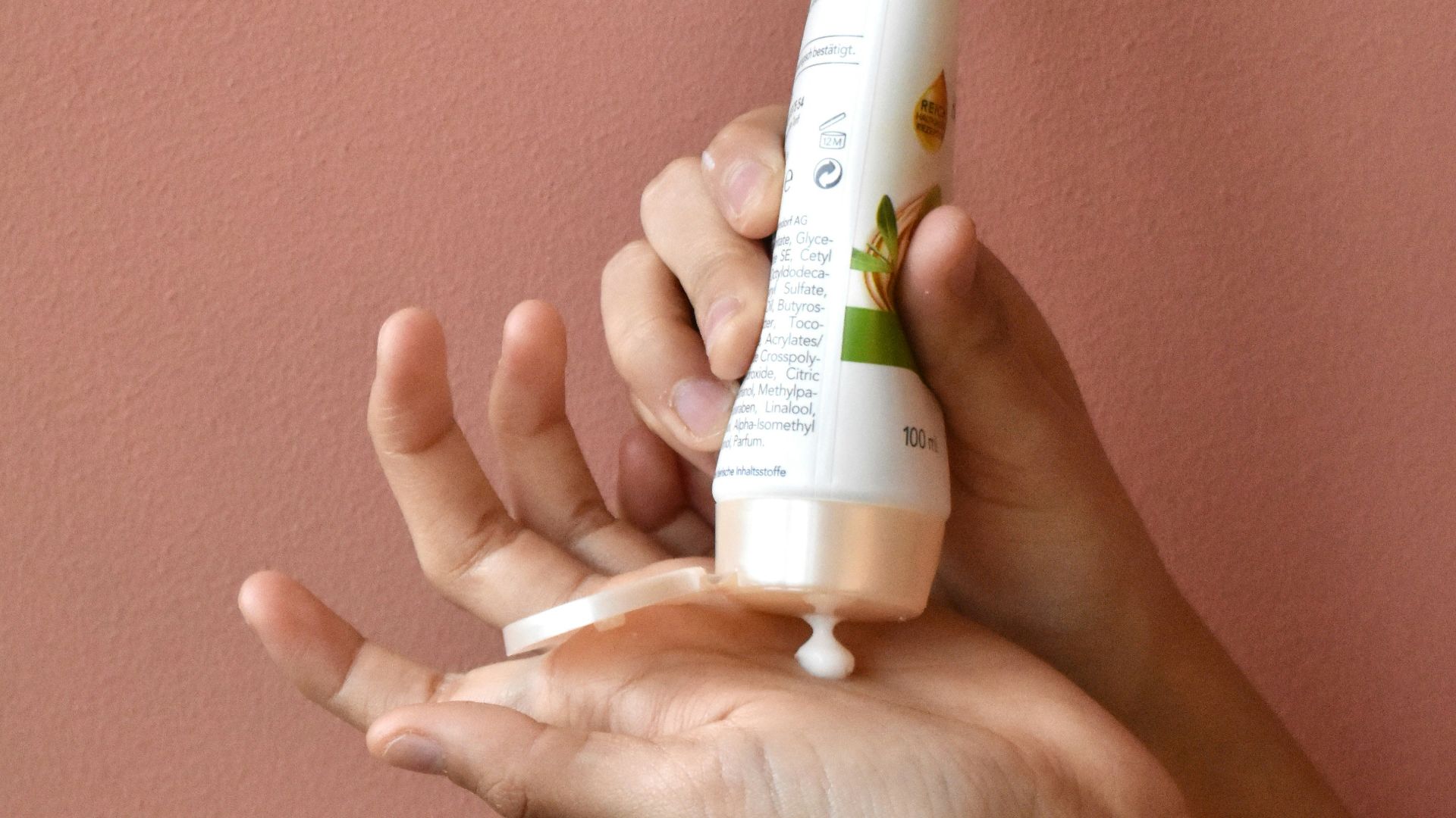 a person holding a tube of toothpaste in their hand