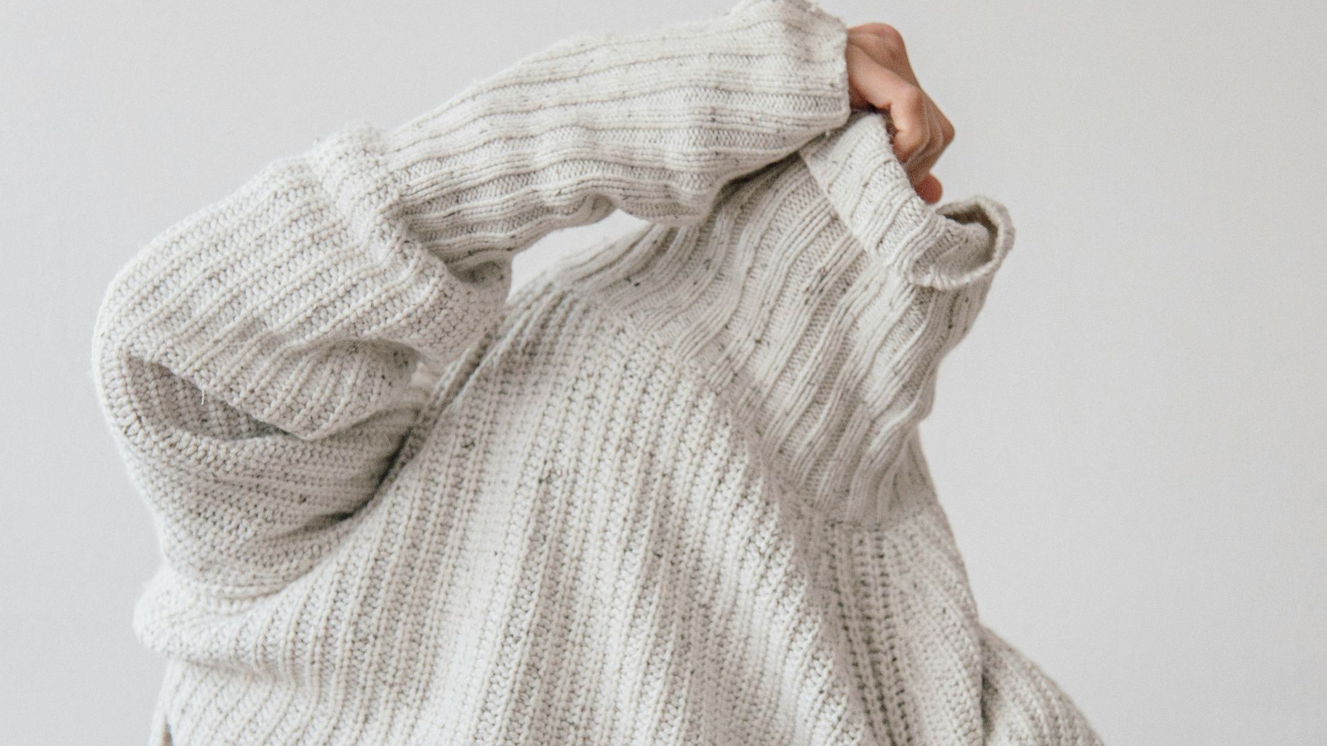 person wearing grey knit sweater