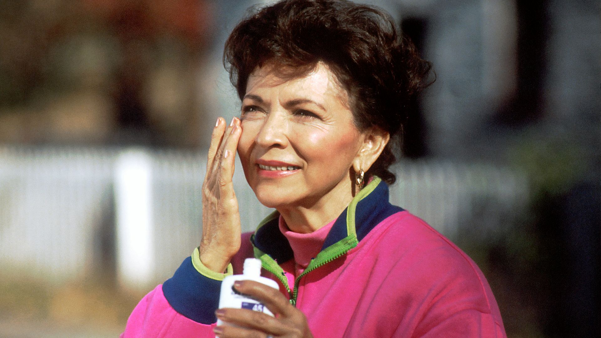 smiling woman in pink and blue shirt