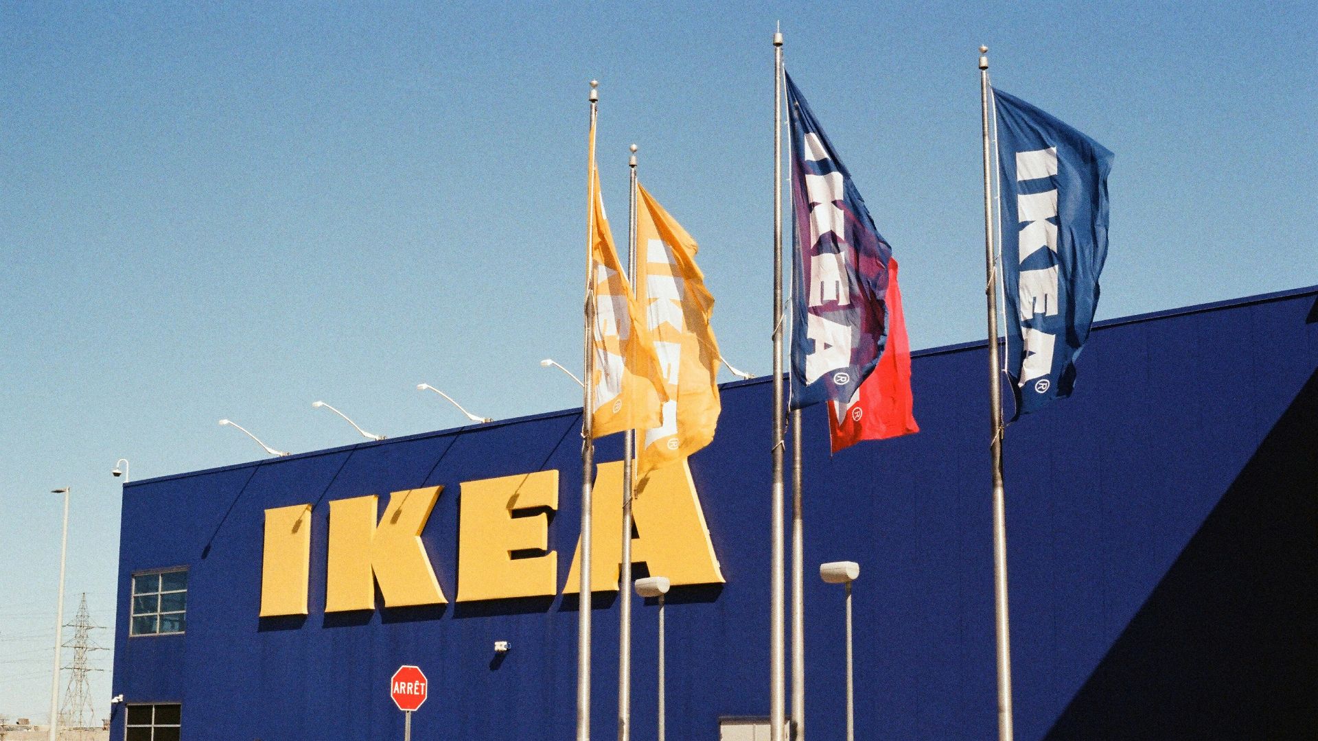 The ikea store with flags and blue exterior.