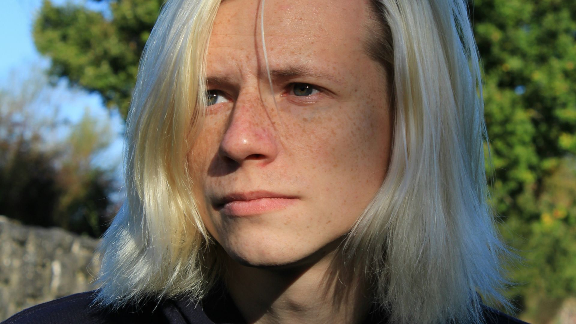 a woman with blonde hair and a black hoodie