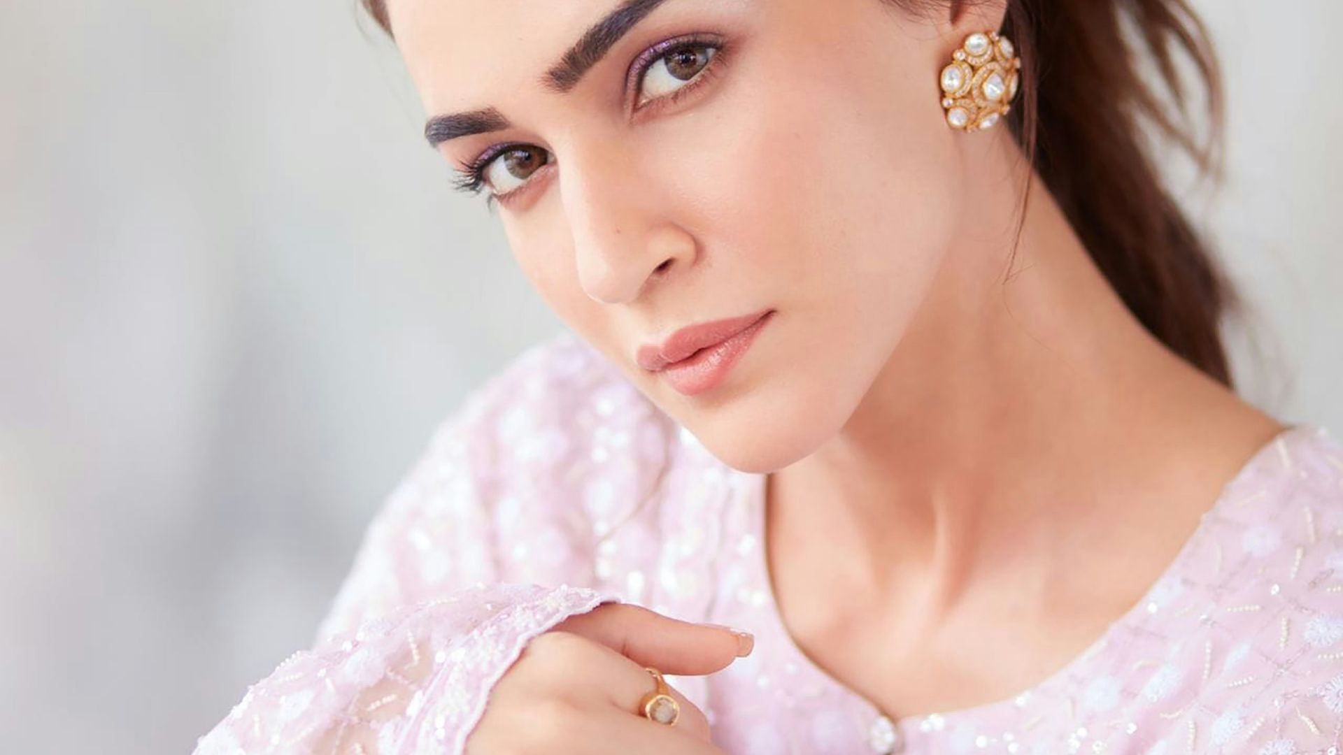 A woman in a pink dress is posing for a picture