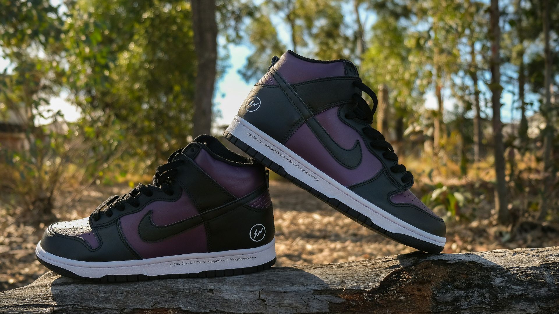 a pair of shoes sitting on top of a log