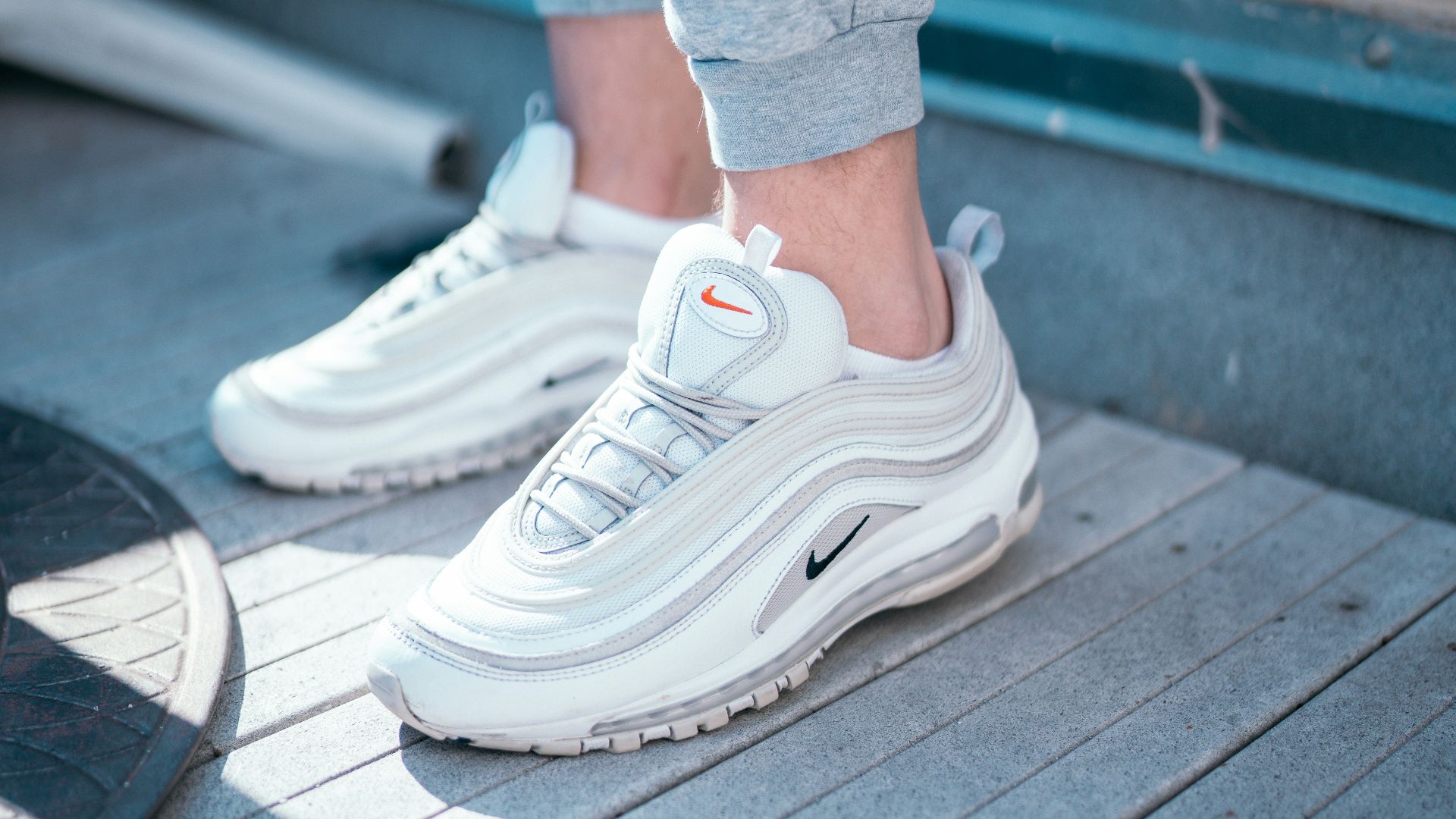 person in gray sweatpants wearing white nike sneakers