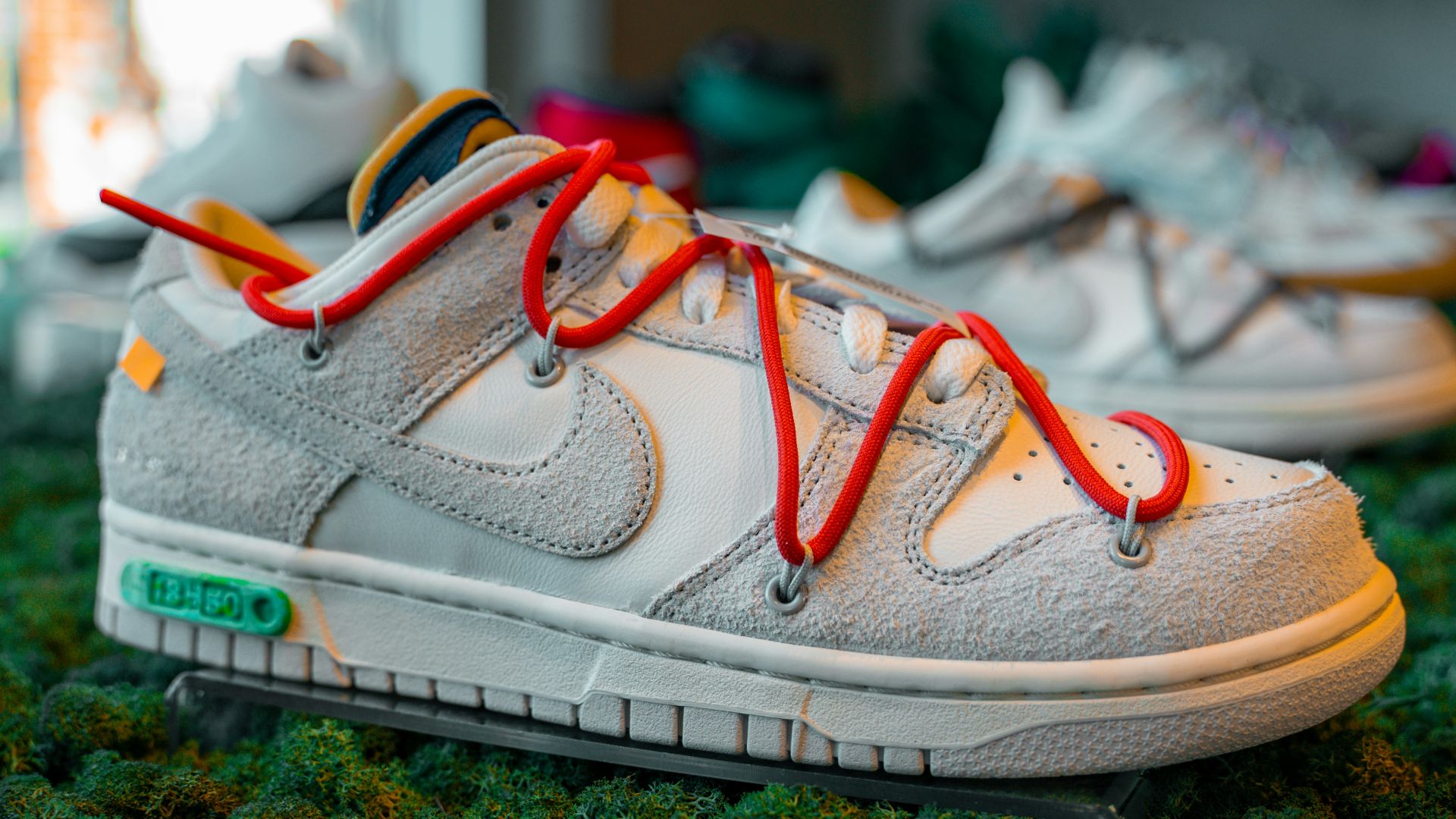 a pair of white sneakers with red laces on them