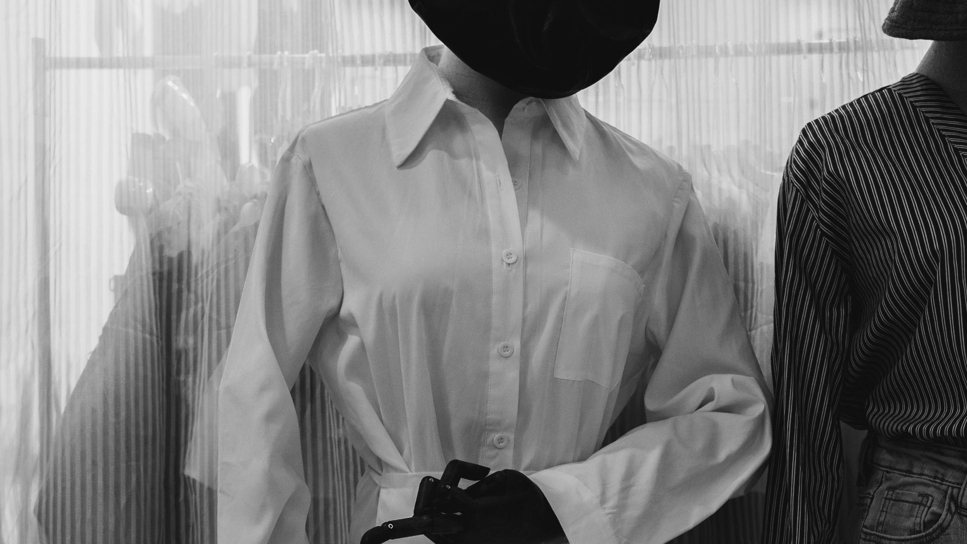 greyscale photography of long-sleeved dress on dress form