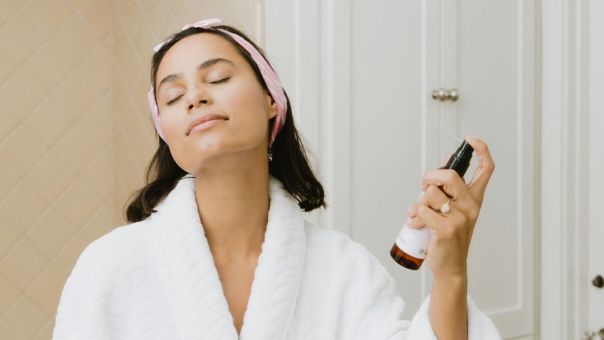 woman in white bathrobe holding smartphone