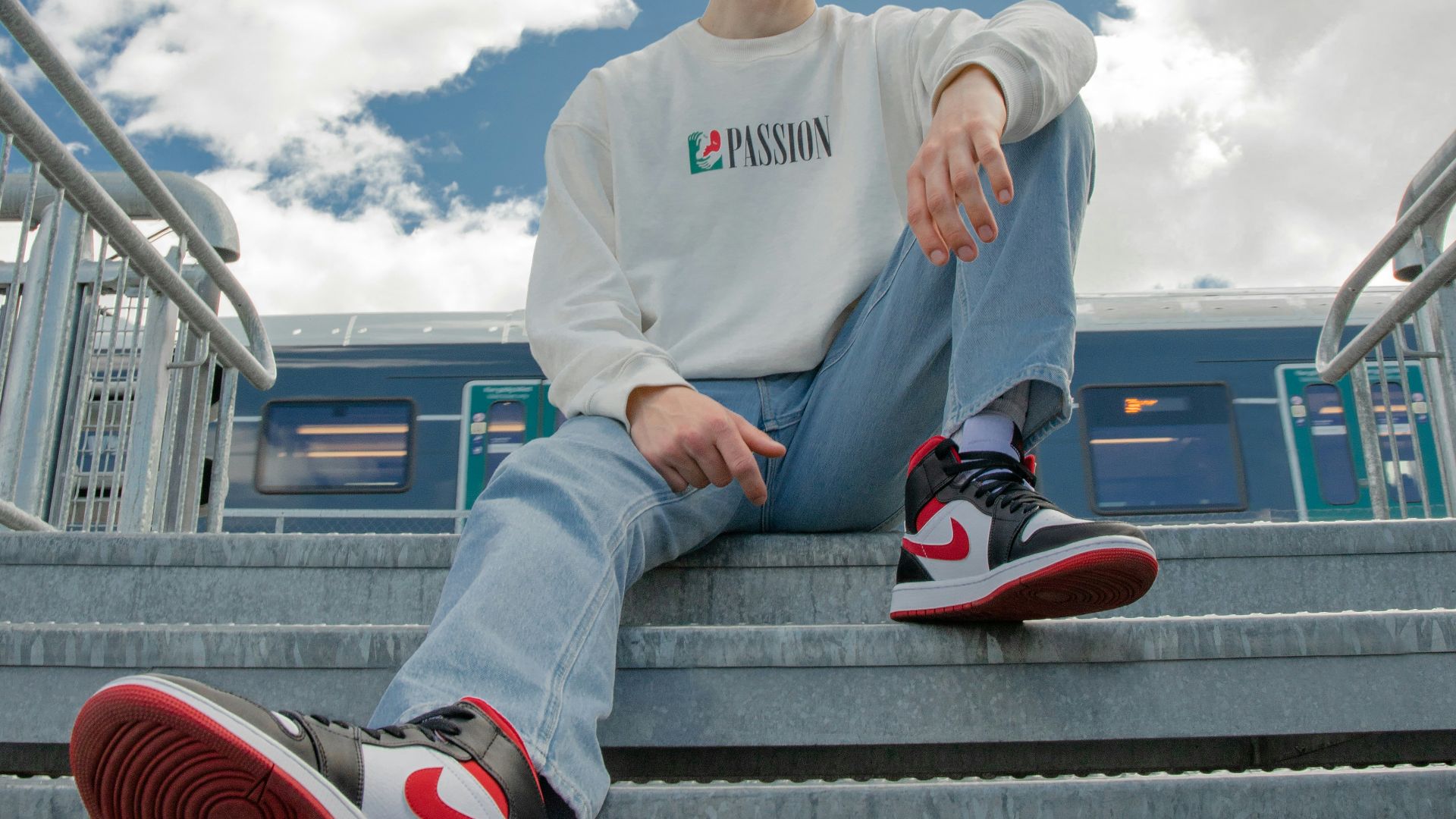 man in white sweater sitting on brown wooden bench during daytime