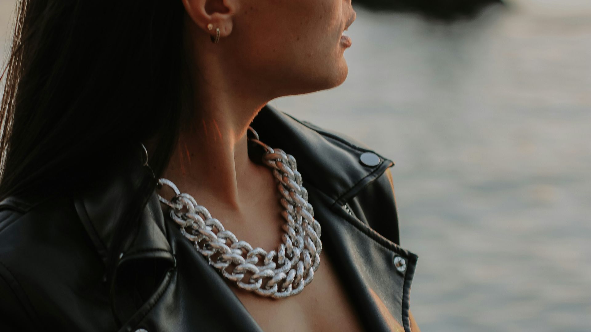 a woman with a tattoo on her neck looking at the water