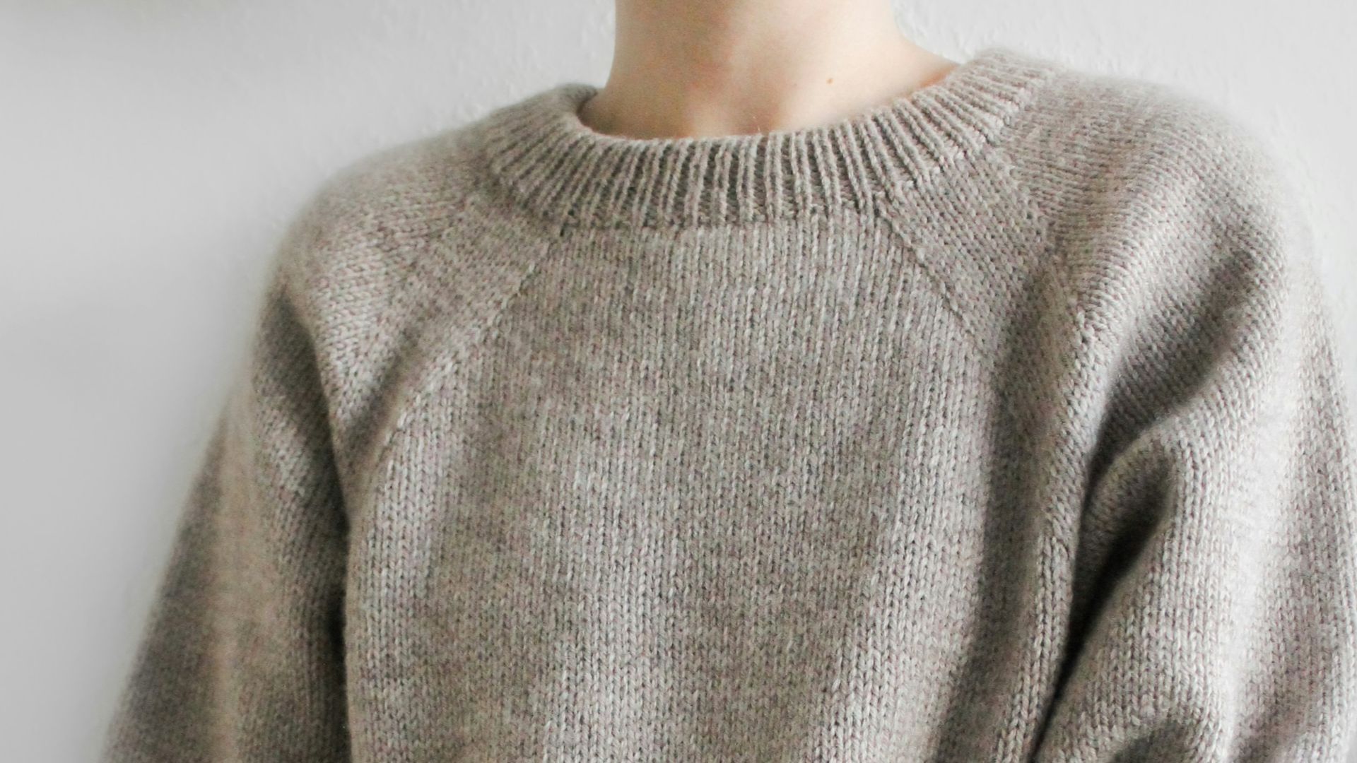 a person wearing a grey sweater