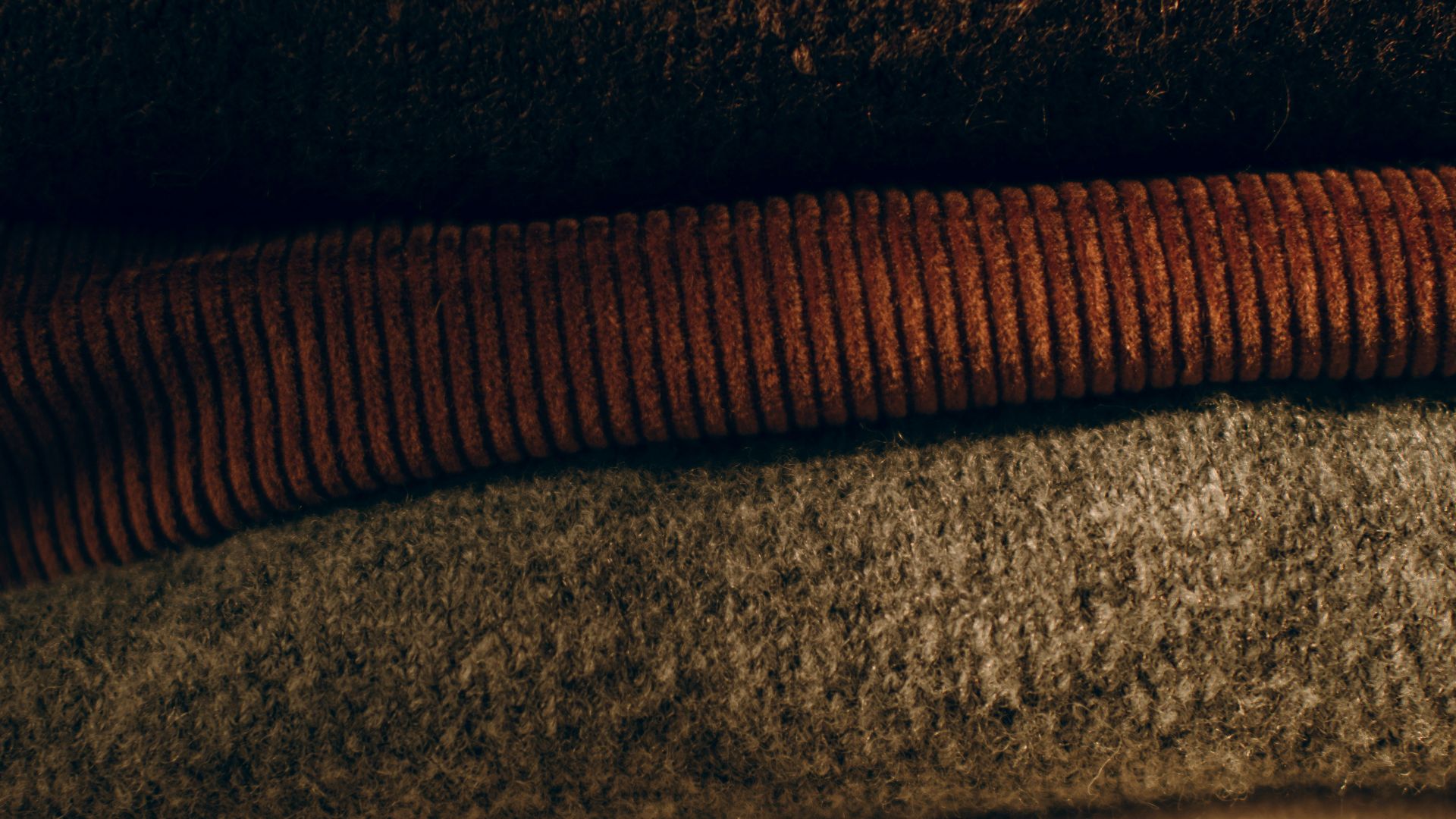 Stack of folded cozy sweaters in neutral colors