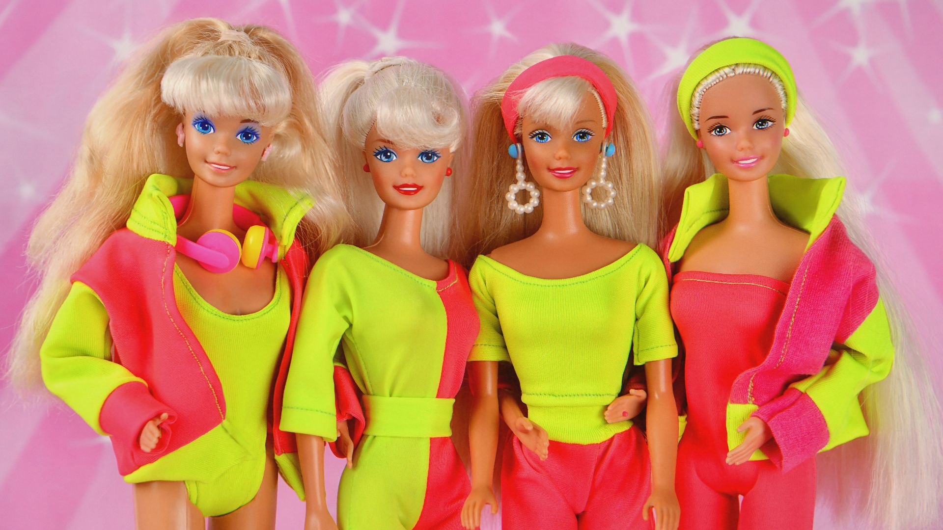 Four 80s barbie dolls posing together.