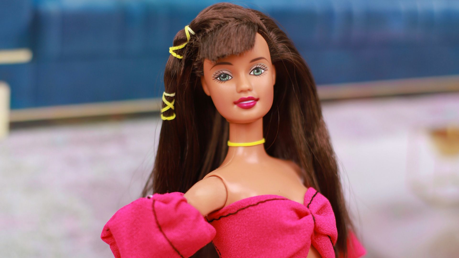 A barbie doll sitting on the floor in a living room