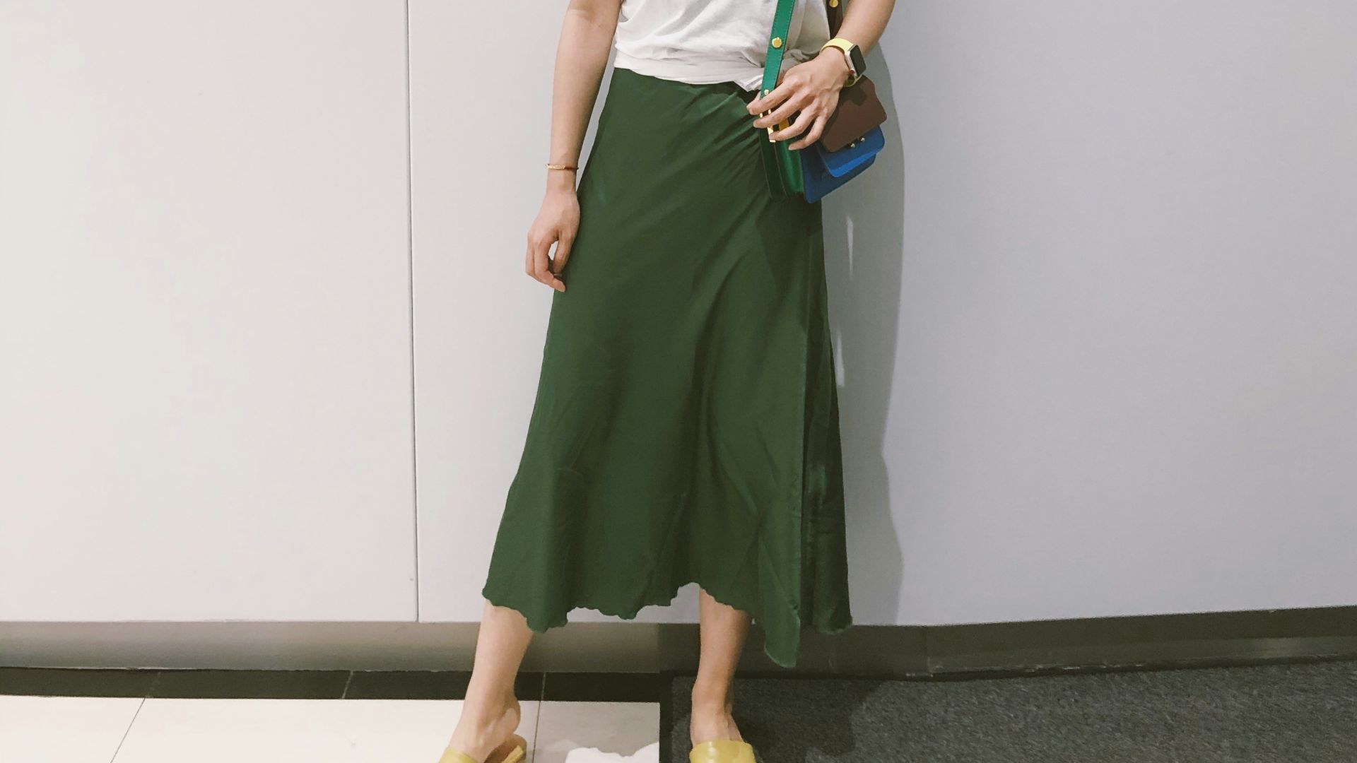 woman looking at her right standing against the wall