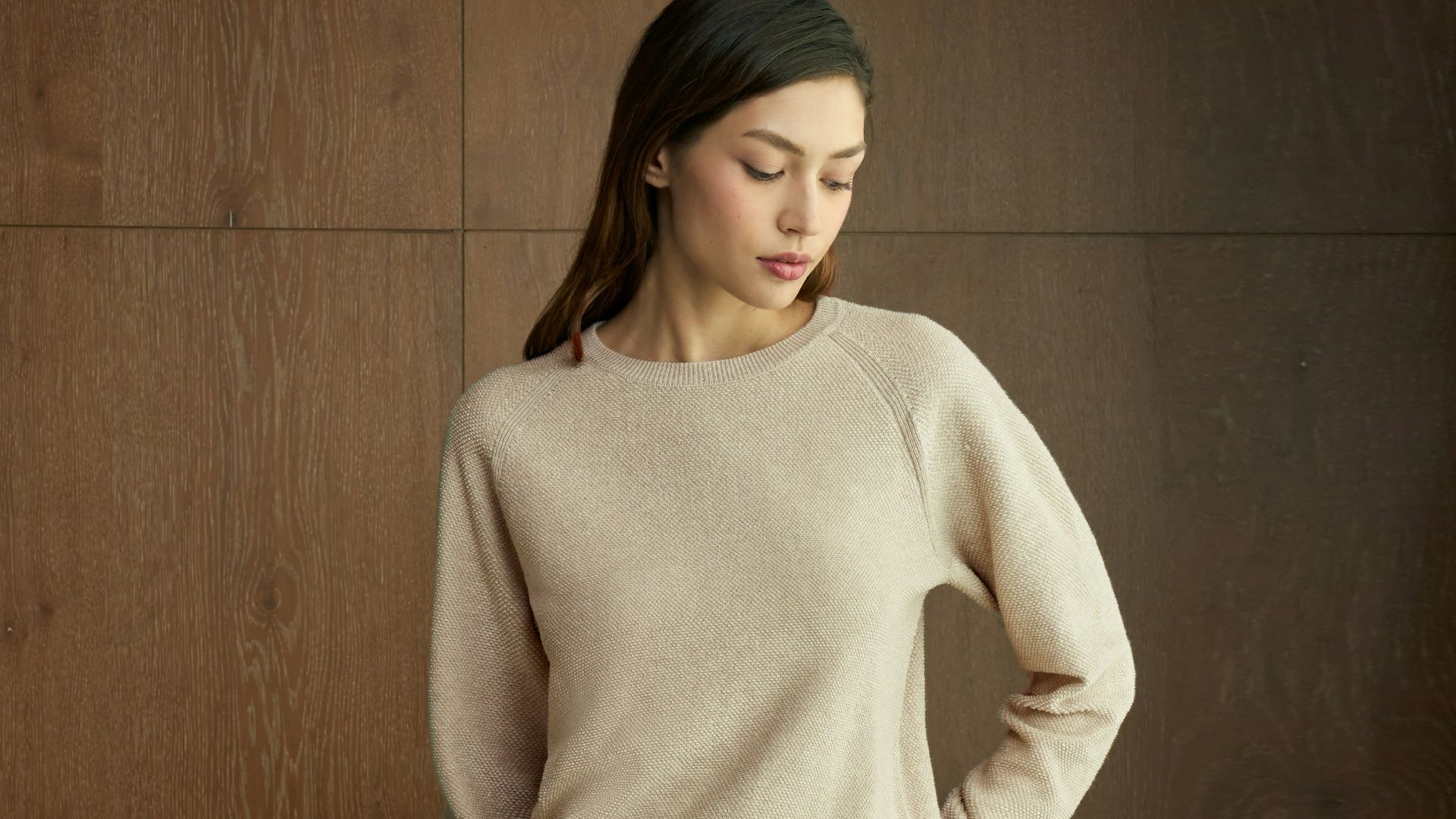 A woman wearing a beige sweater and pants.