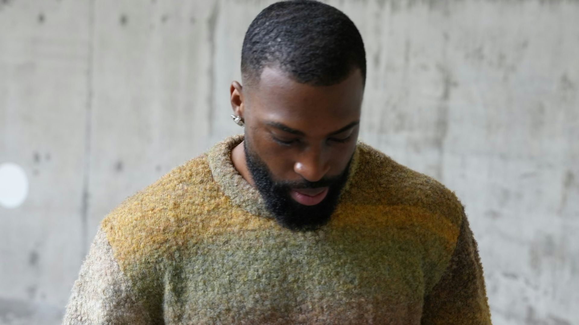 a man with a beard wearing a multicolored sweater