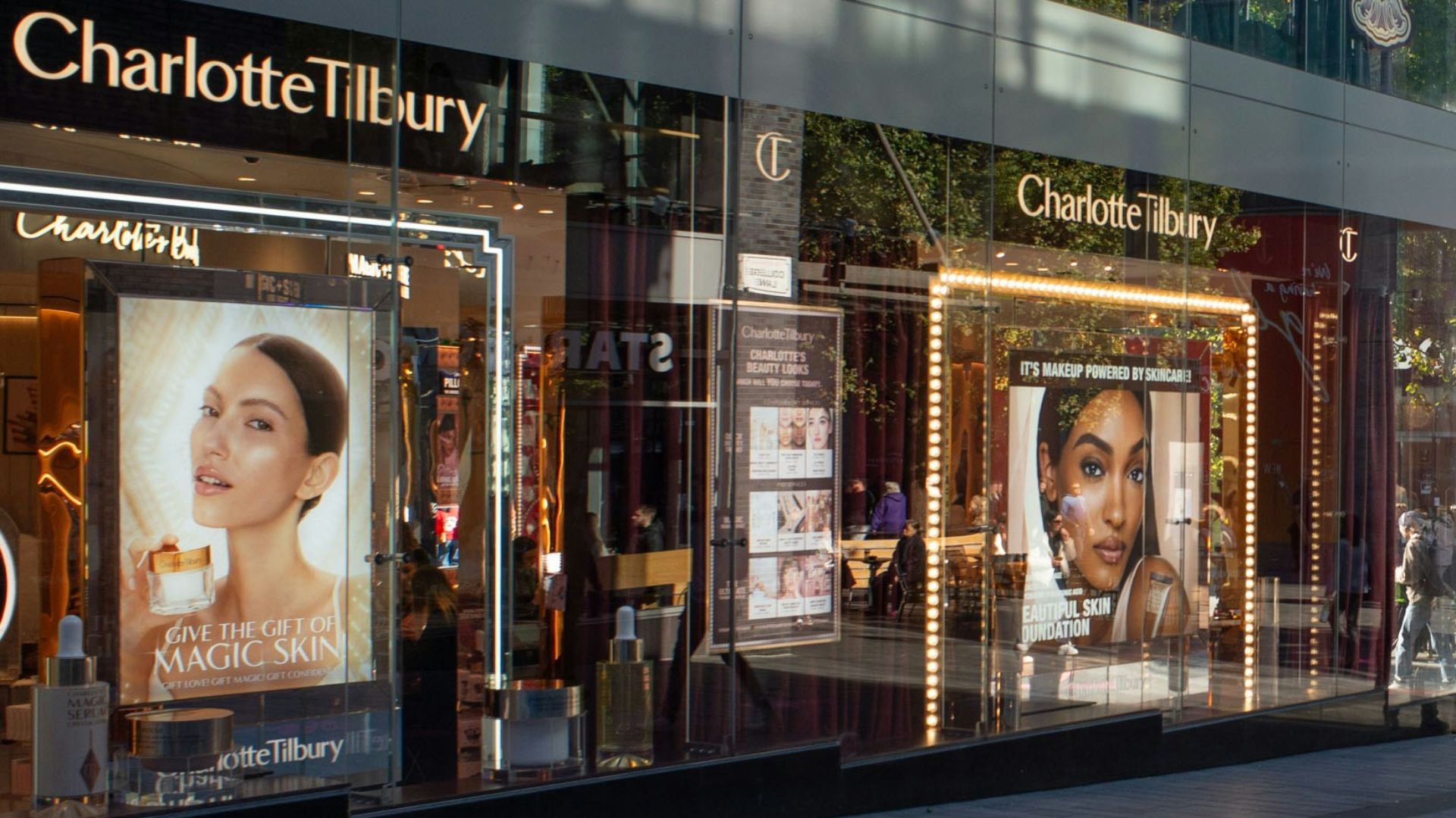 A group of people walking down a street next to tall buildings