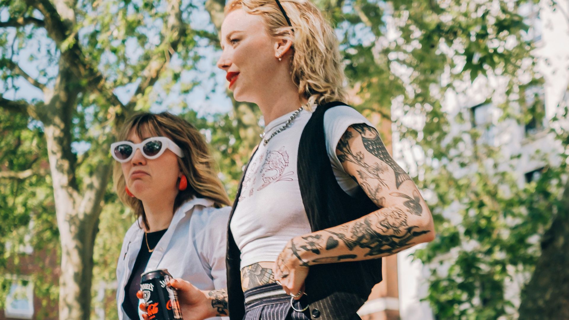 a couple of women walking across a lush green park