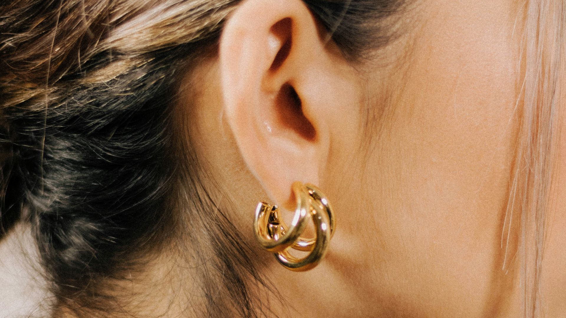 a close up of a person wearing a pair of earrings