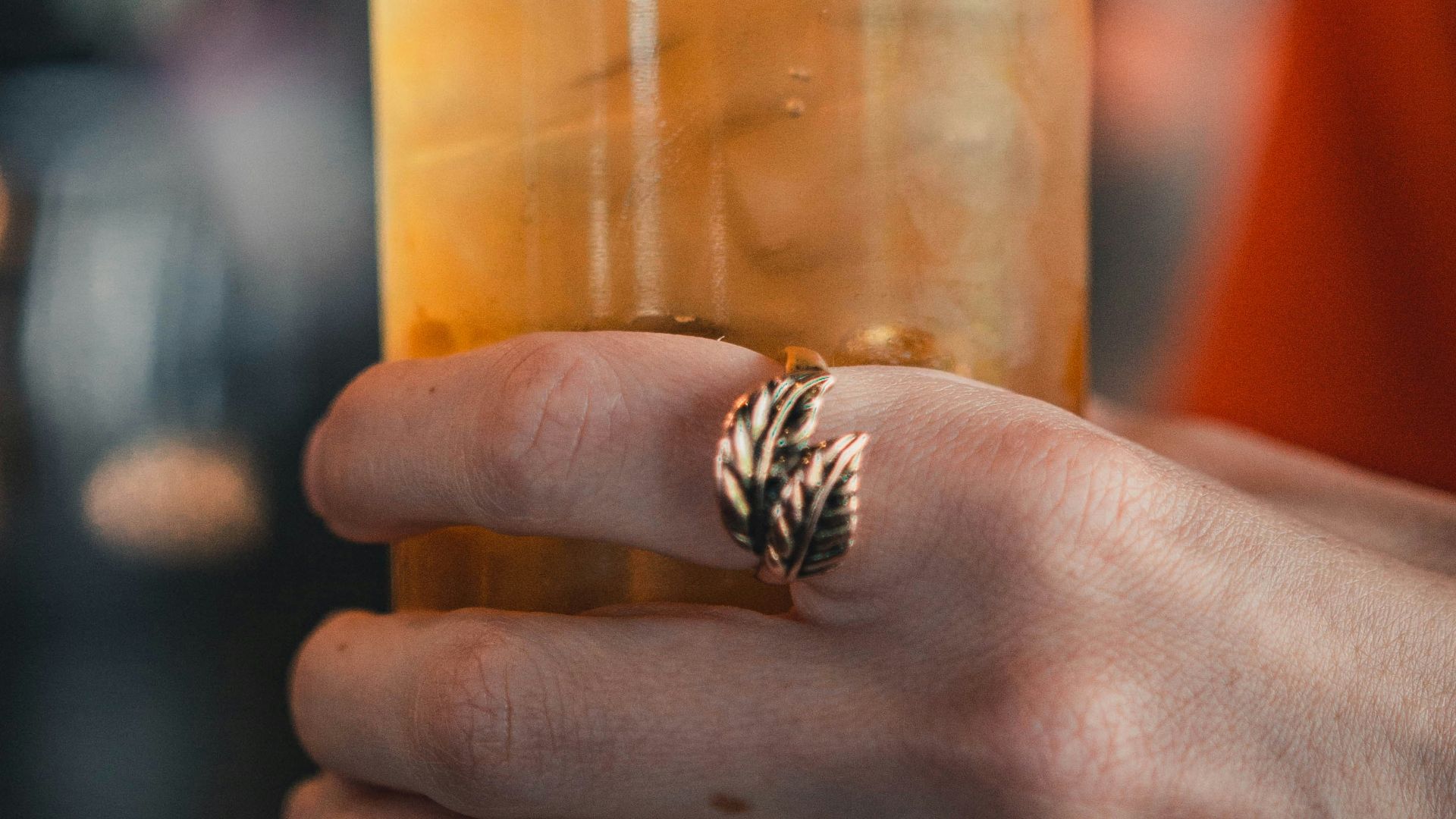 person holding clear drinking glass with juice
