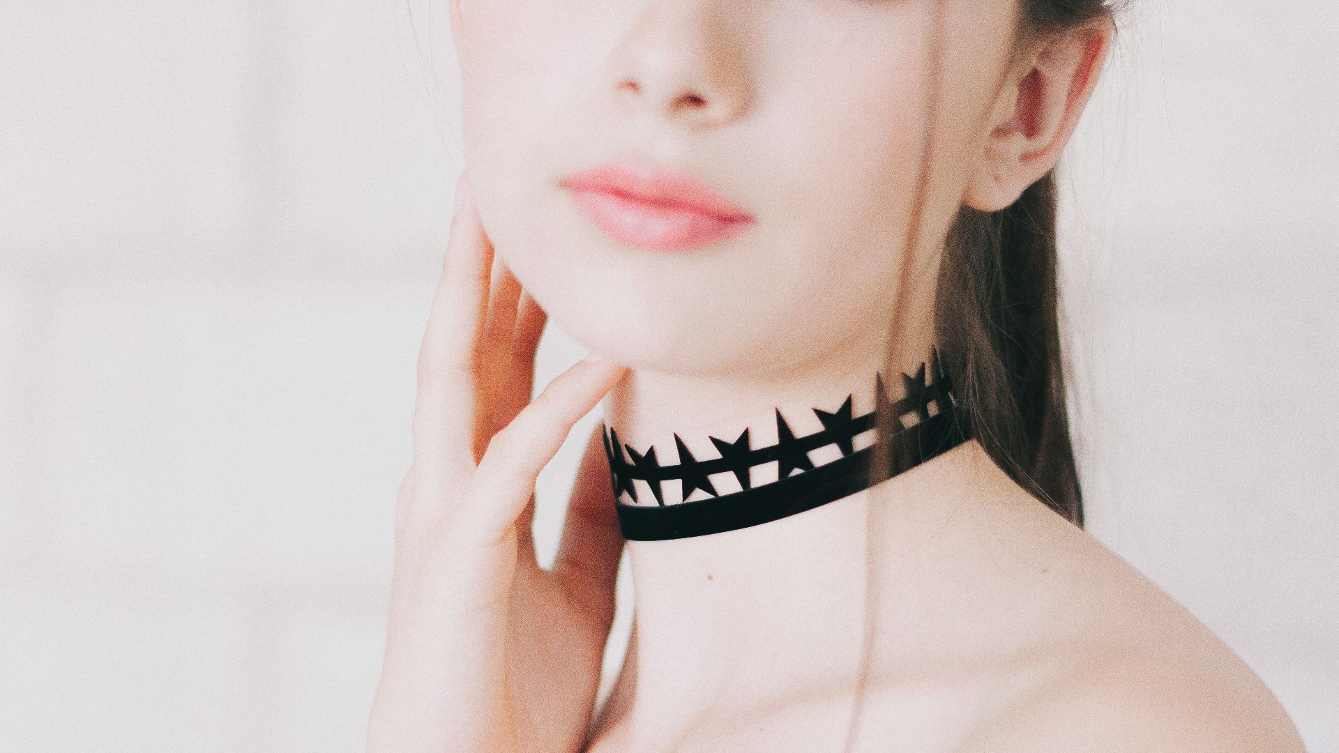 Woman wears a star-shaped choker necklace.