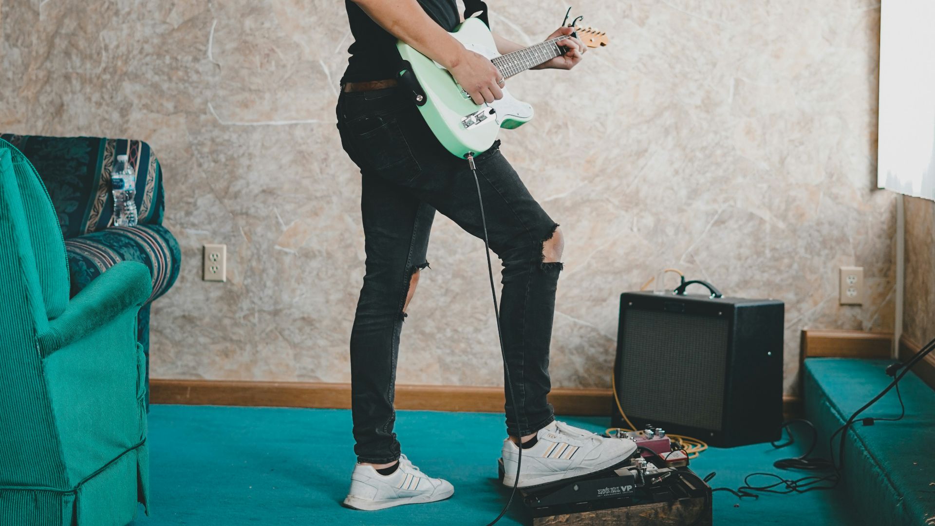 man in black t-shirt playing guitar
